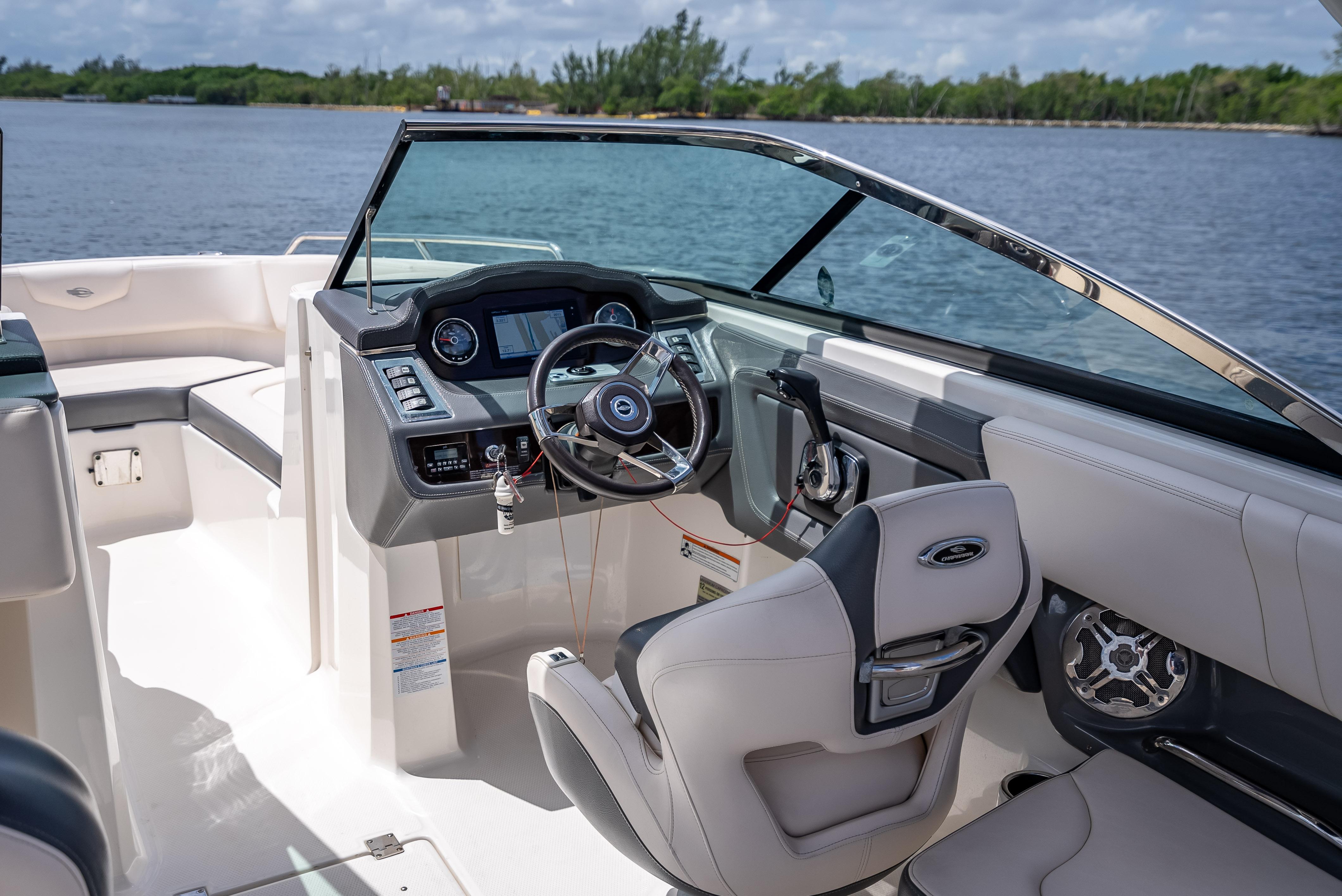 2017 Chaparral 227 SSX boat interior with steering wheel and dashboard, near water.