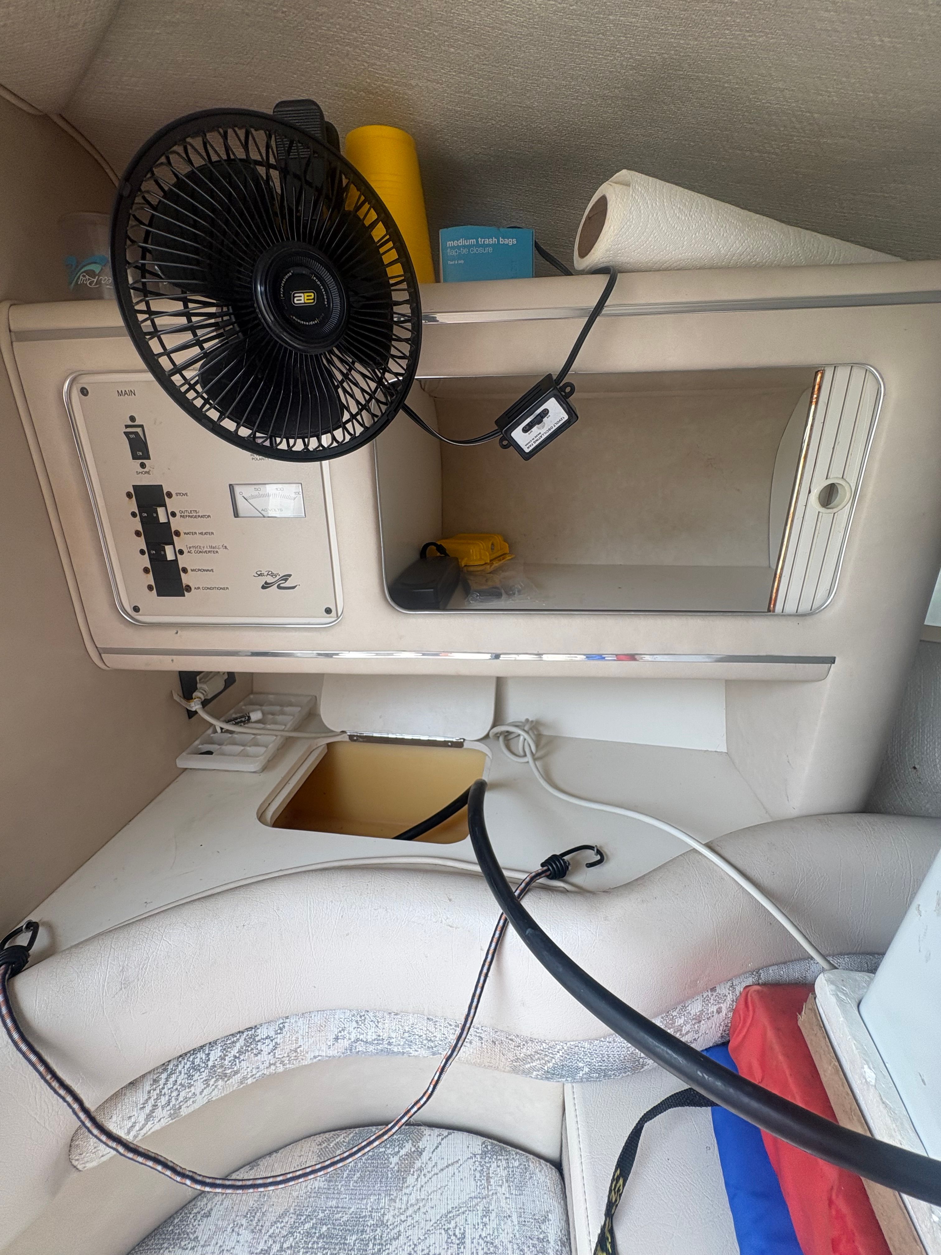 Interior of a 1996 Sea Ray 280 Cuddy Cabin with control panel and fan.