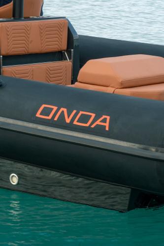 2024 Onda Magna boat with orange seats and black exterior on water.