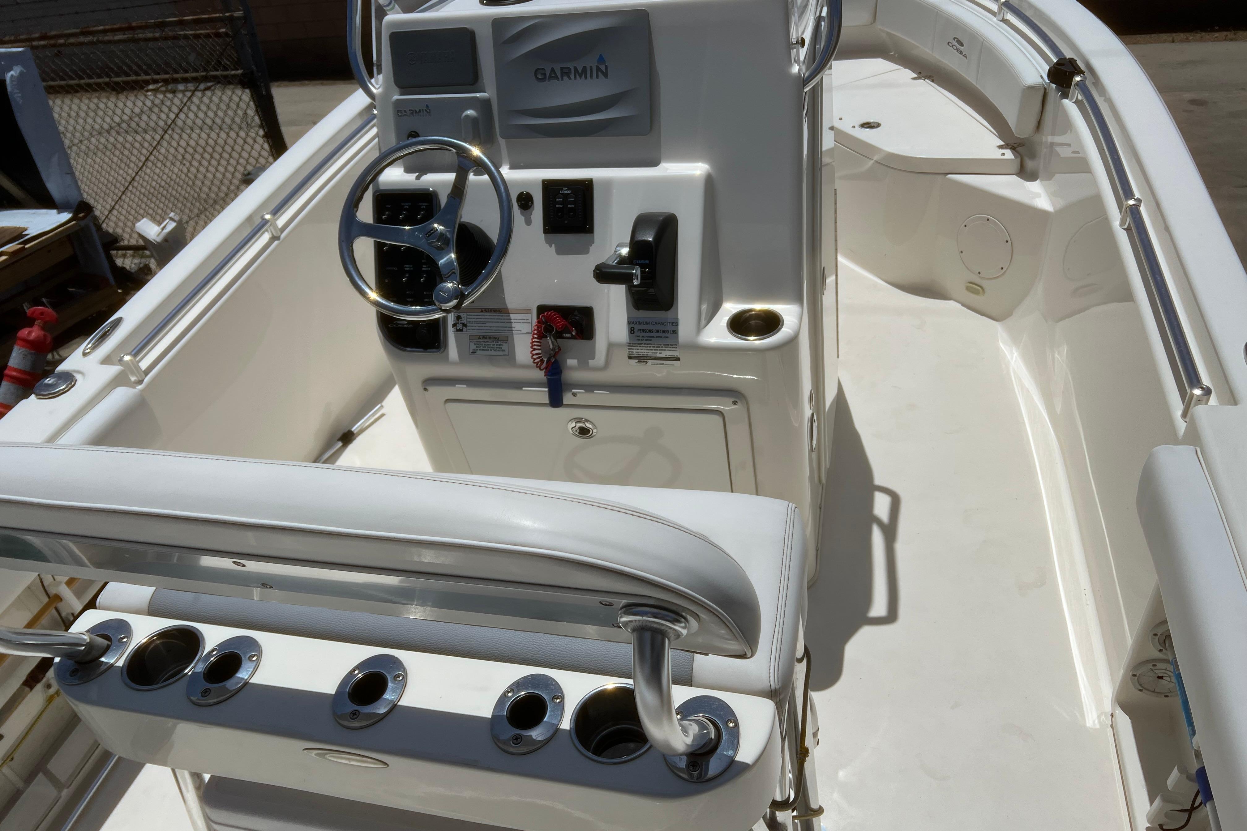2018 Cobia 201 Center Console boat interior with steering wheel and Garmin navigation system.