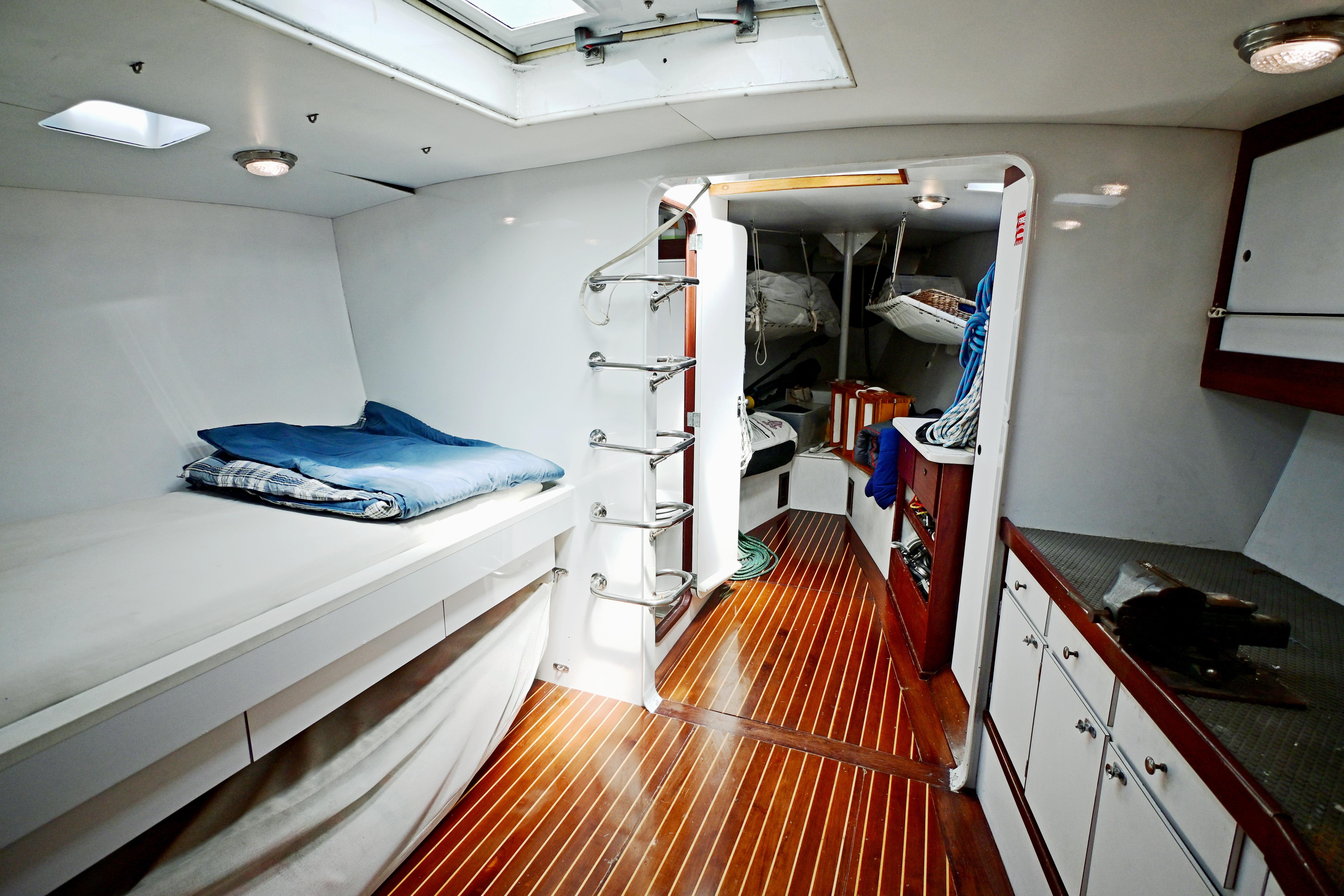Interior of 1968 Abeking & Rasmussen Tripp 74 yacht with wooden flooring and cozy sleeping area.