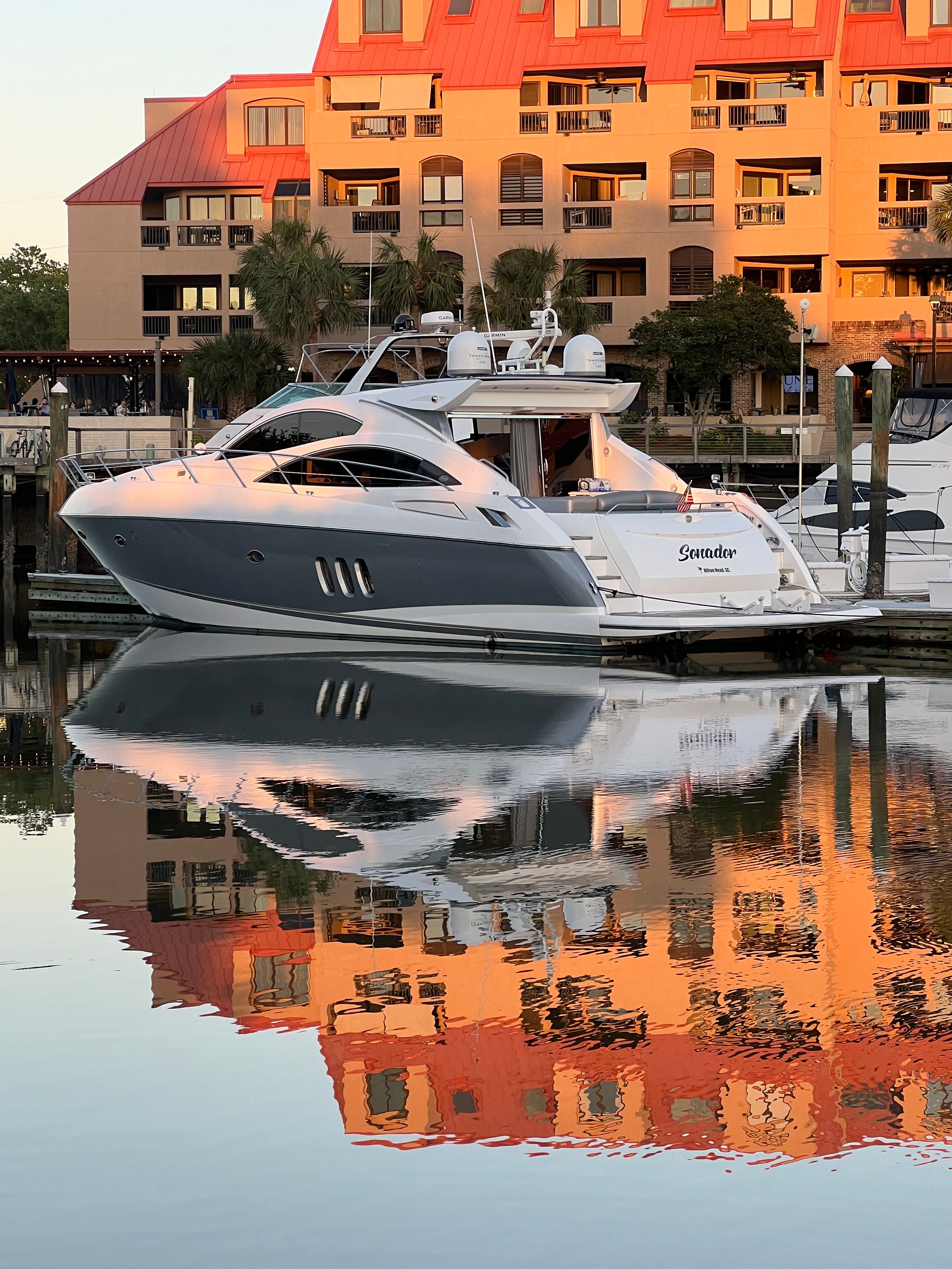 2008 Sunseeker Predator 62 yacht docked, reflecting in calm water.