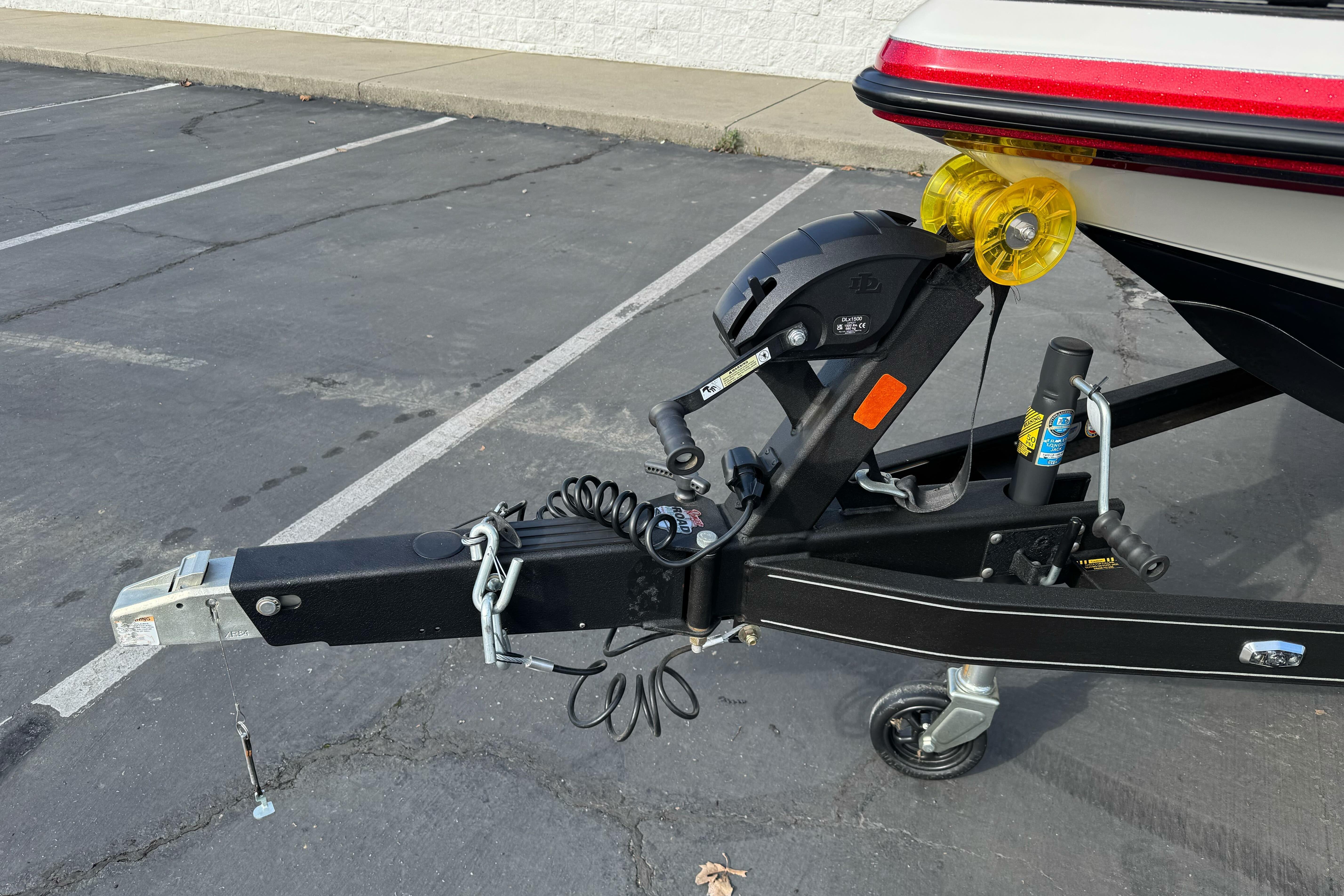 2025 Ranger Z521 boat trailer hitch with winch and safety chains in parking lot.