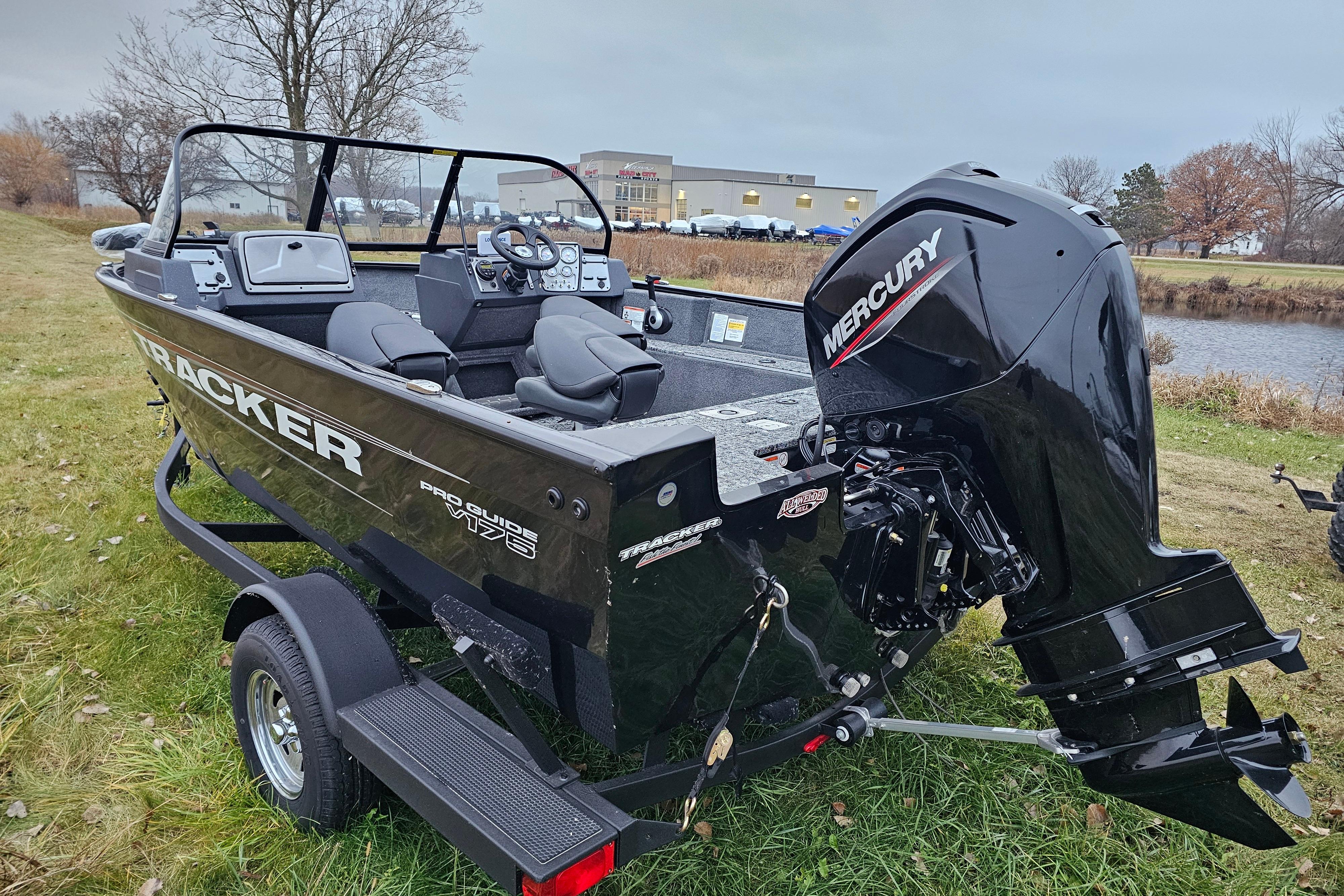 2026 Tracker Pro Guide V-175 WT boat with Mercury engine on grassy shore.