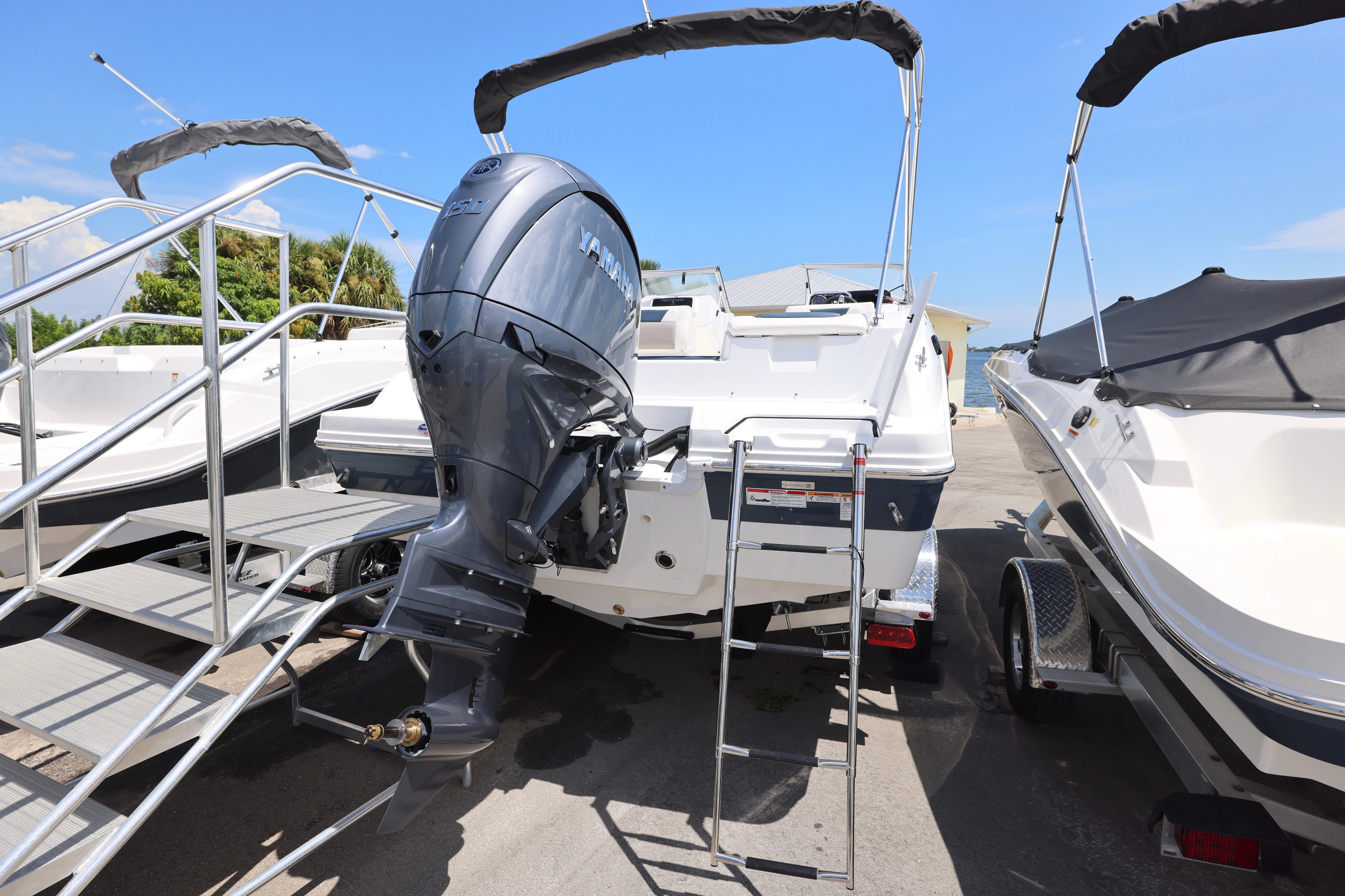 2026 Hurricane SunDeck 2050 OB boat with Yamaha outboard motor, docked with ladder access.