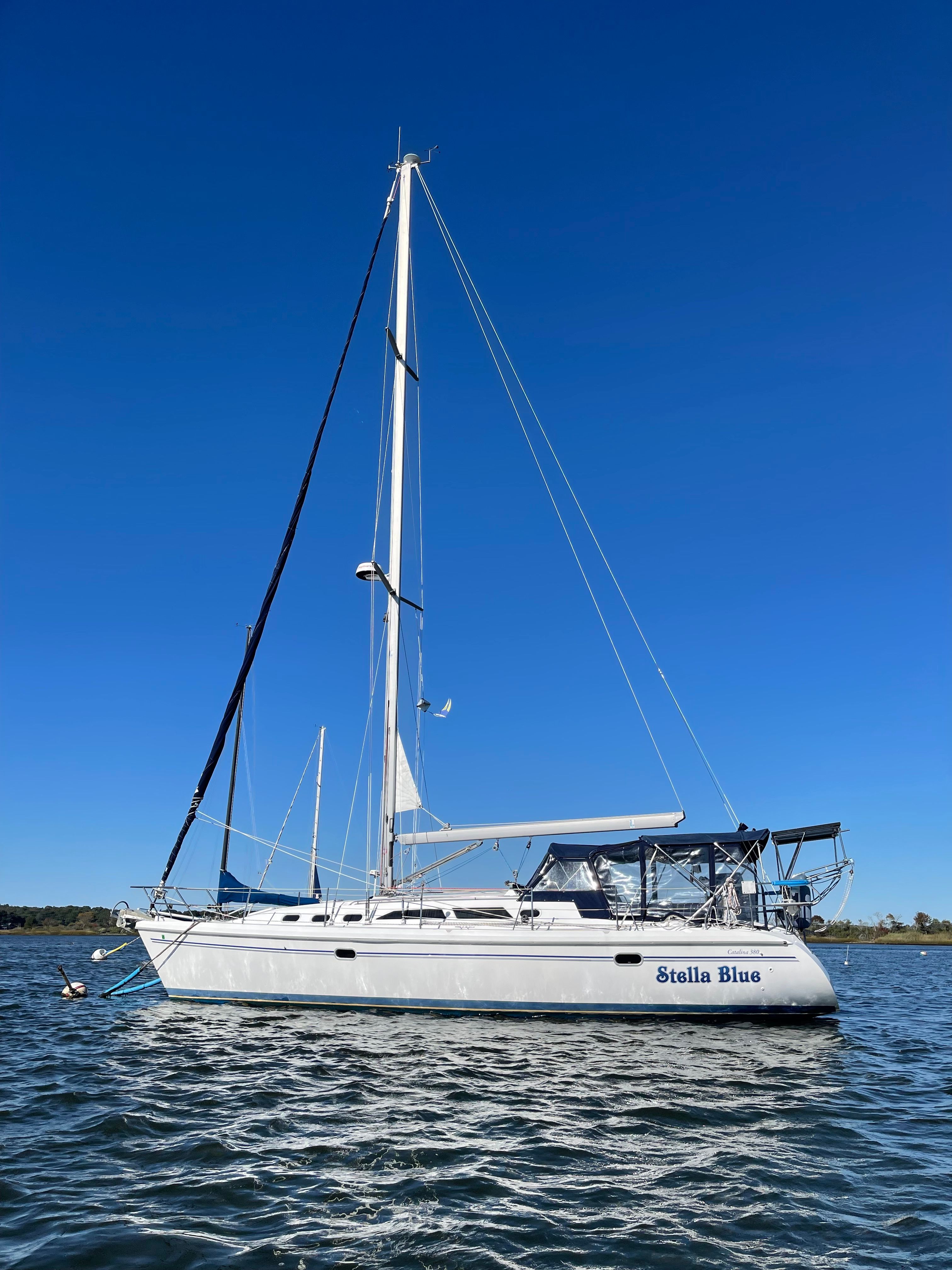 2003 Catalina 380 sailboat on calm water under blue sky.