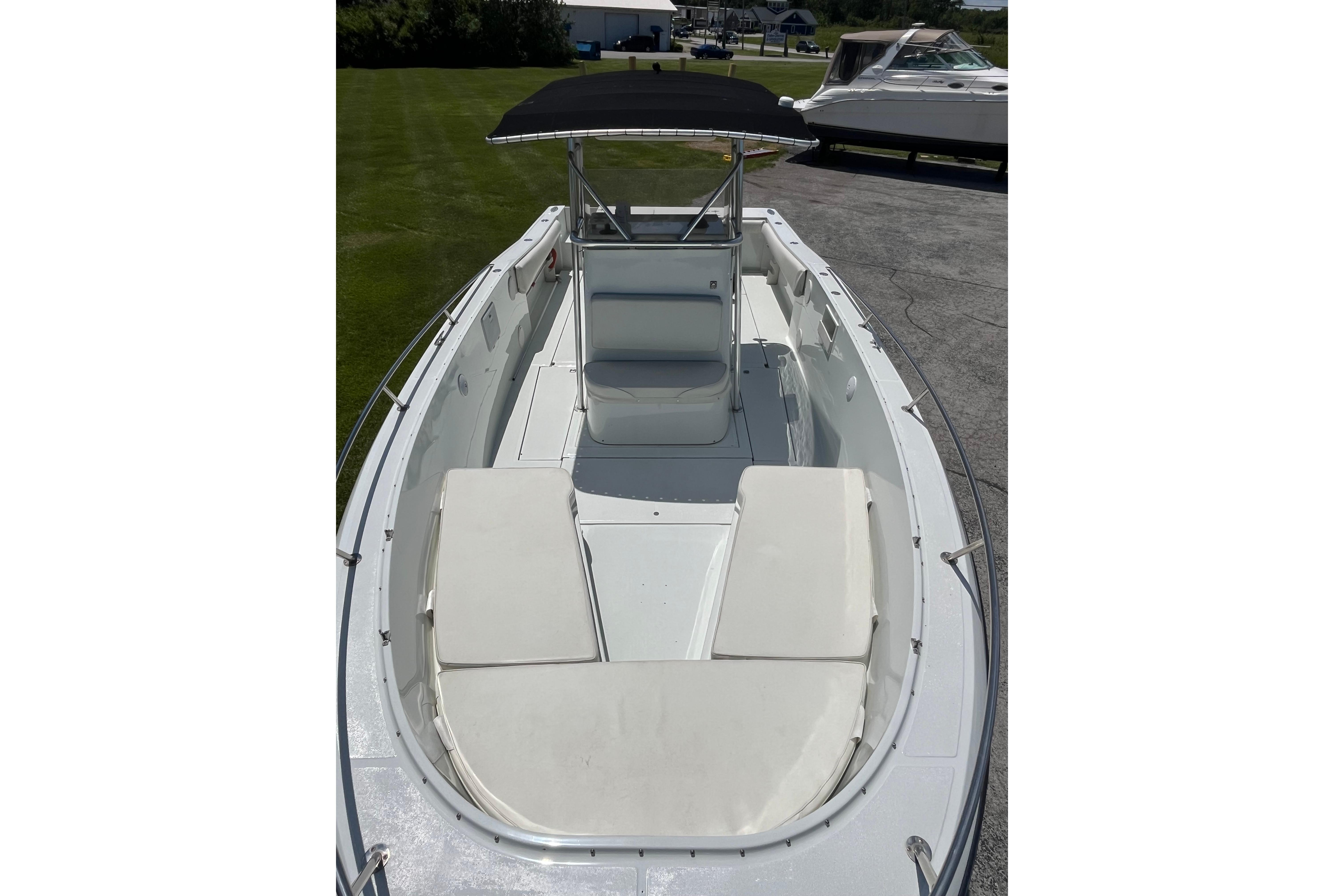 1997 Stamas boat with cushioned seating and canopy, parked on pavement.