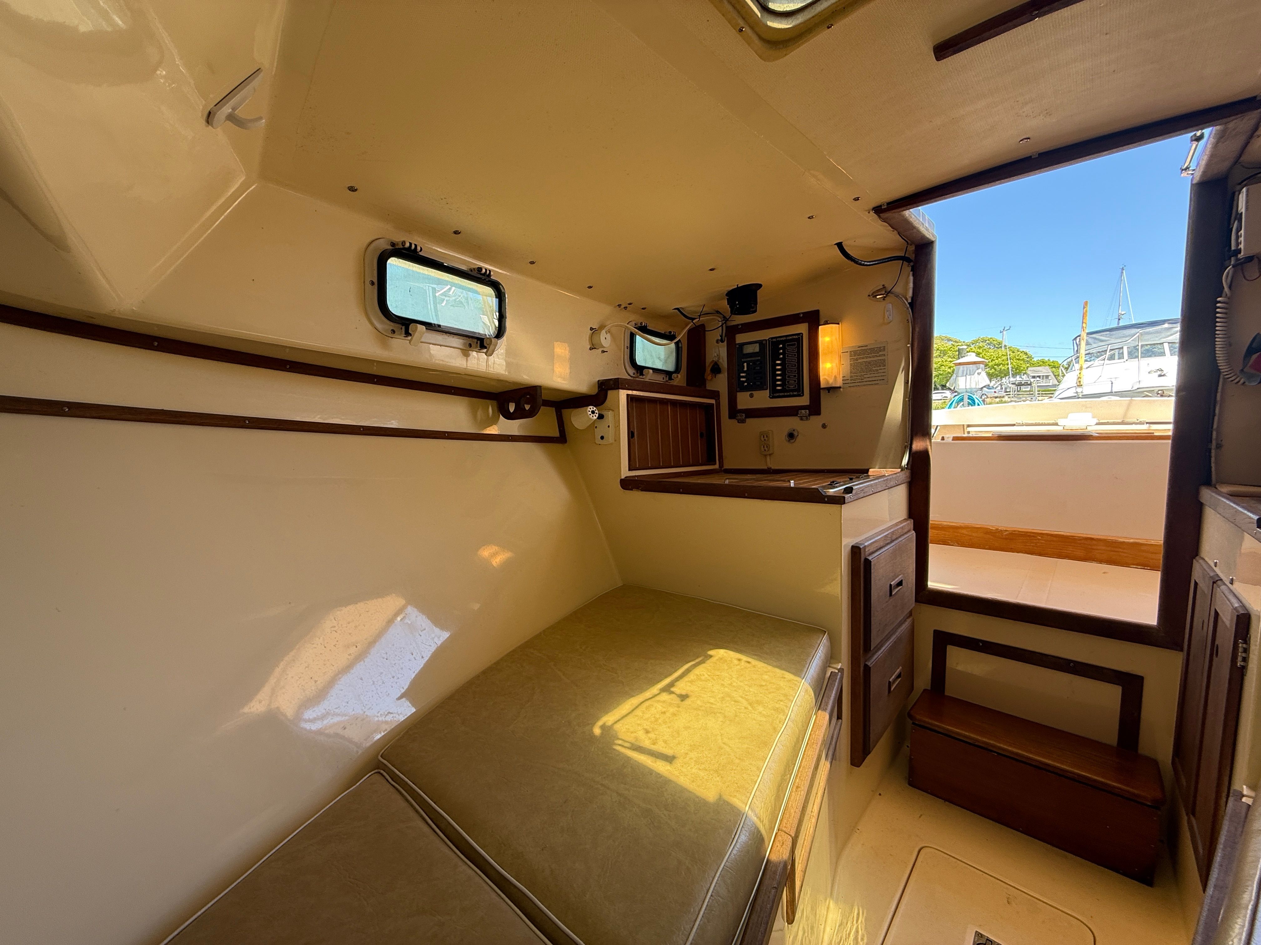 Interior of a 1989 Fortier 26 with seating and control panel.