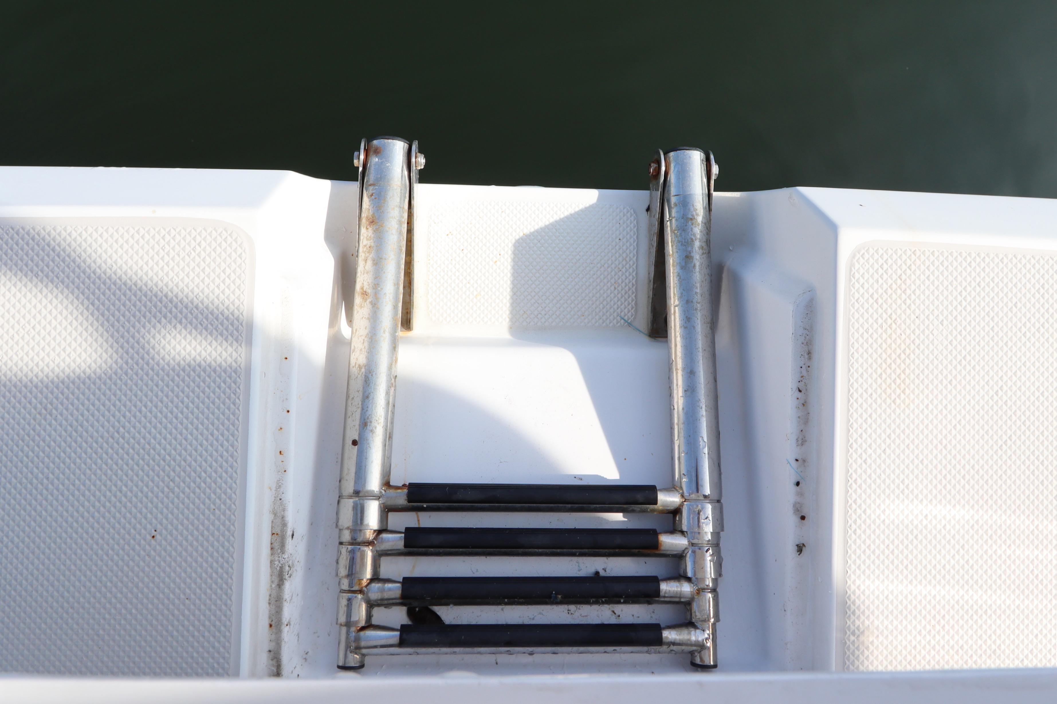 Stainless steel boat ladder on 2011 Catalina 355 yacht, extending into water.