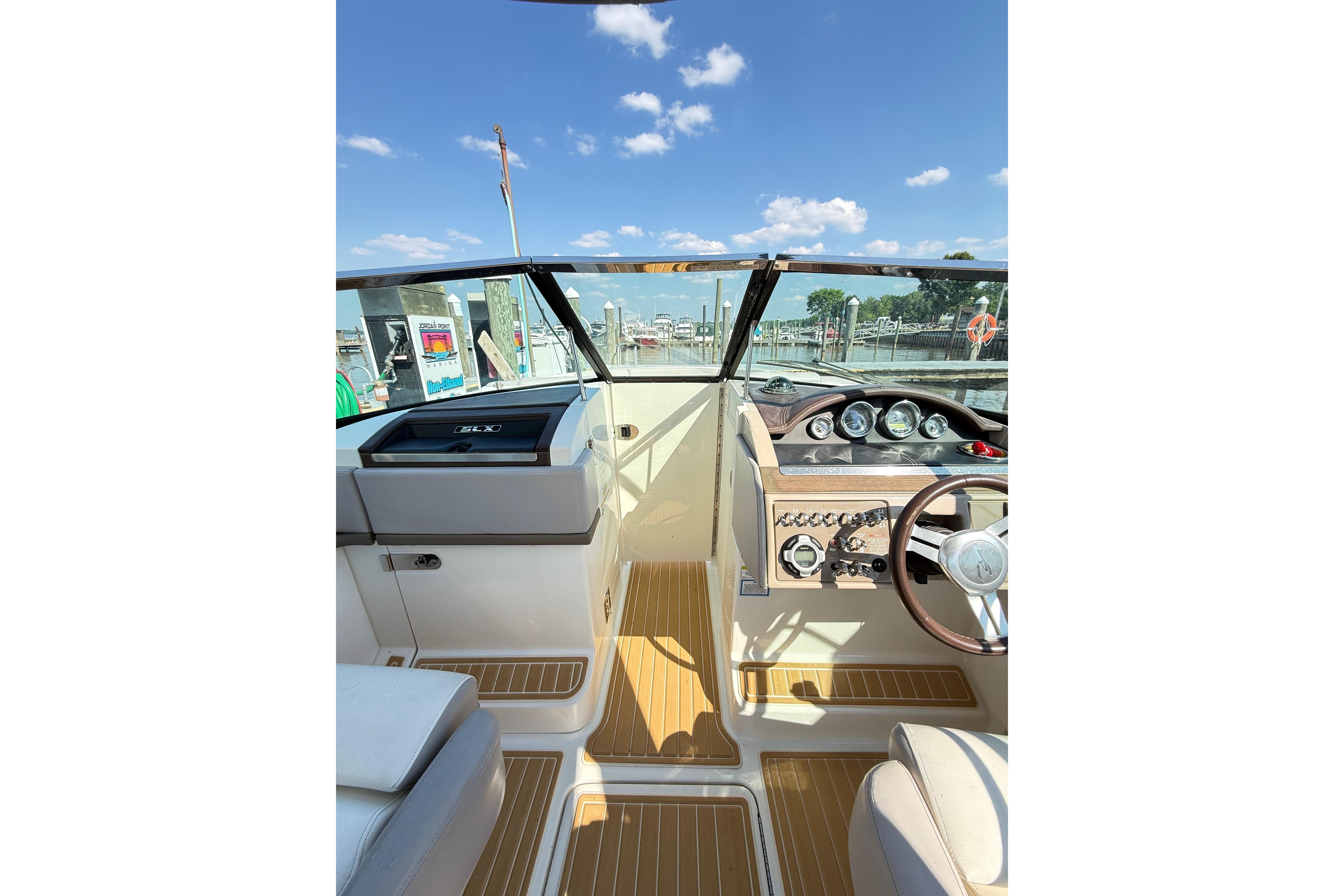 Interior view of 2011 Sea Ray 270 SLX boat cockpit with steering wheel and dashboard.