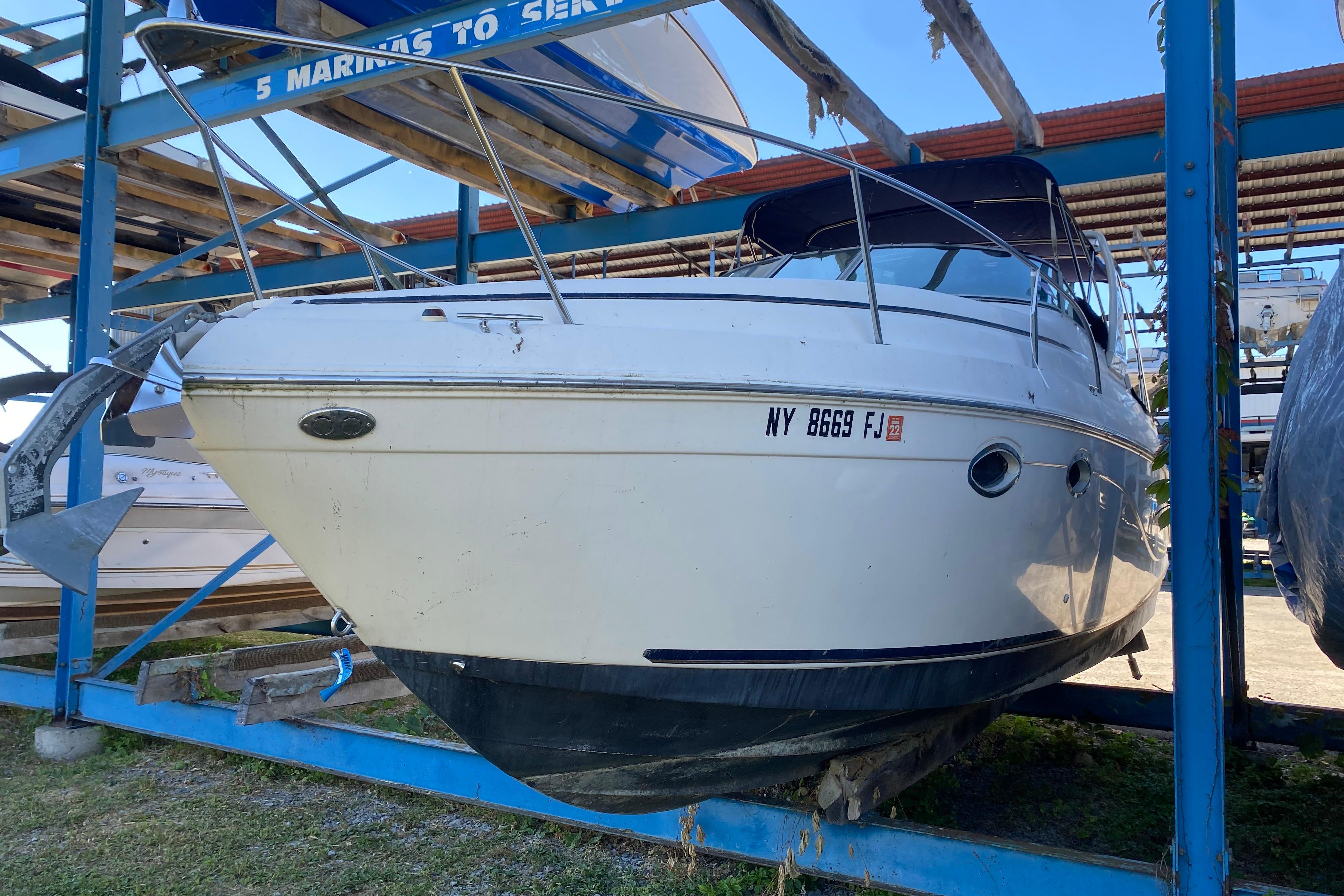 2003 Rinker Fiesta Vee 270 boat on dry dock, front view, with visible registration number.