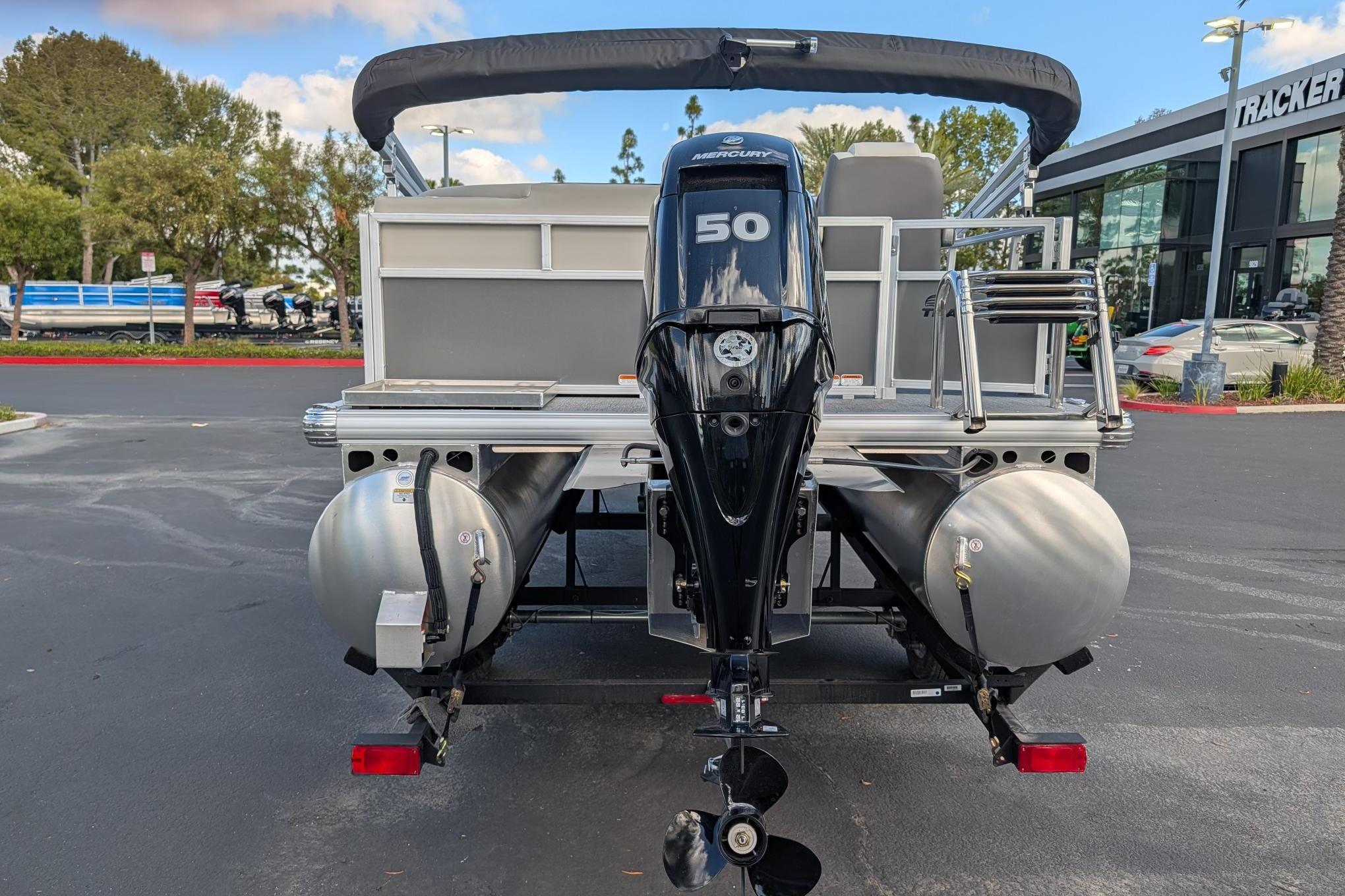 2026 Sun Tracker Bass Buggy 16 XL Select pontoon boat with Mercury 50 engine, rear view.