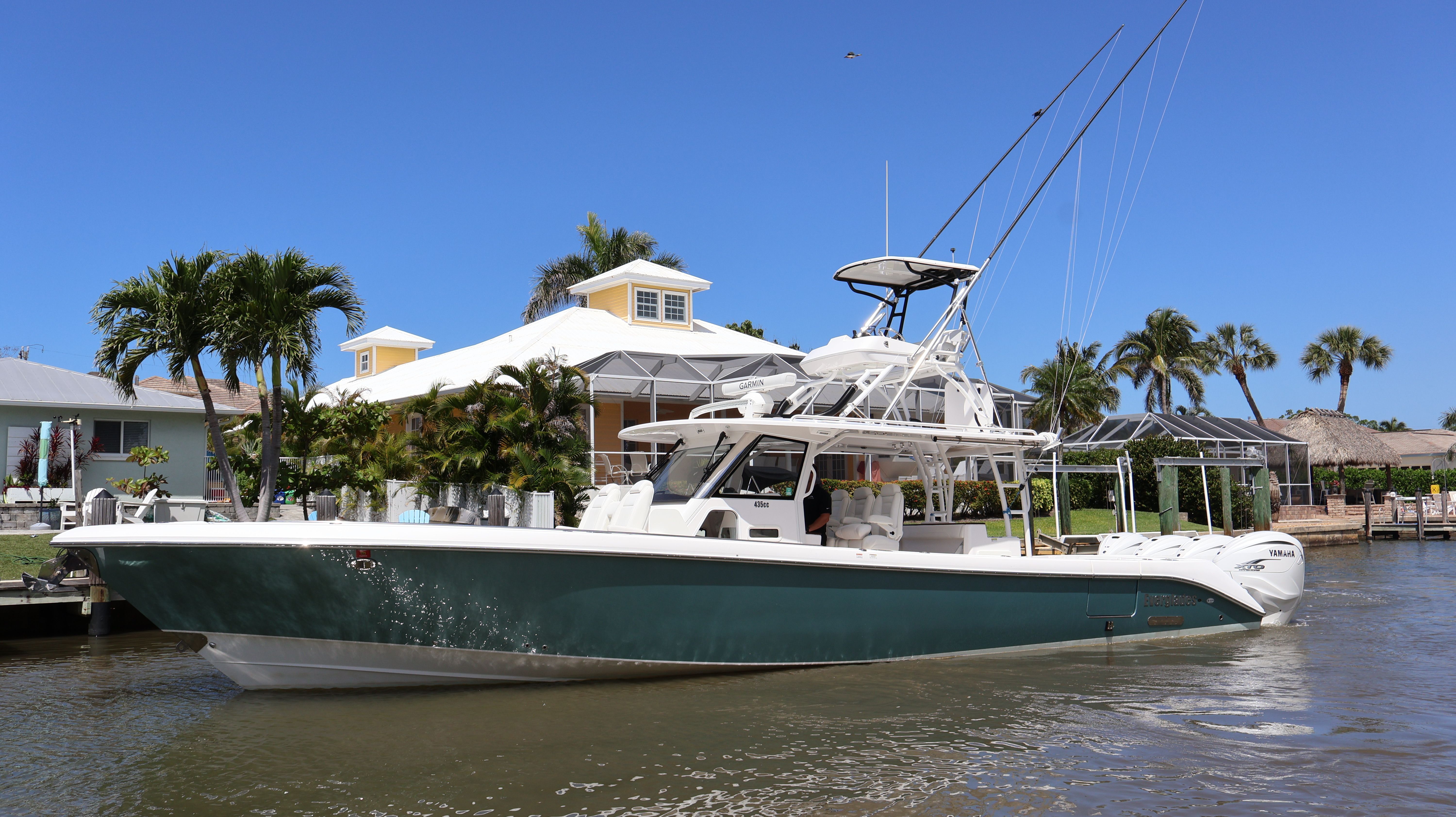 2019 Everglades 435 Center Console boat on water with tropical backdrop.