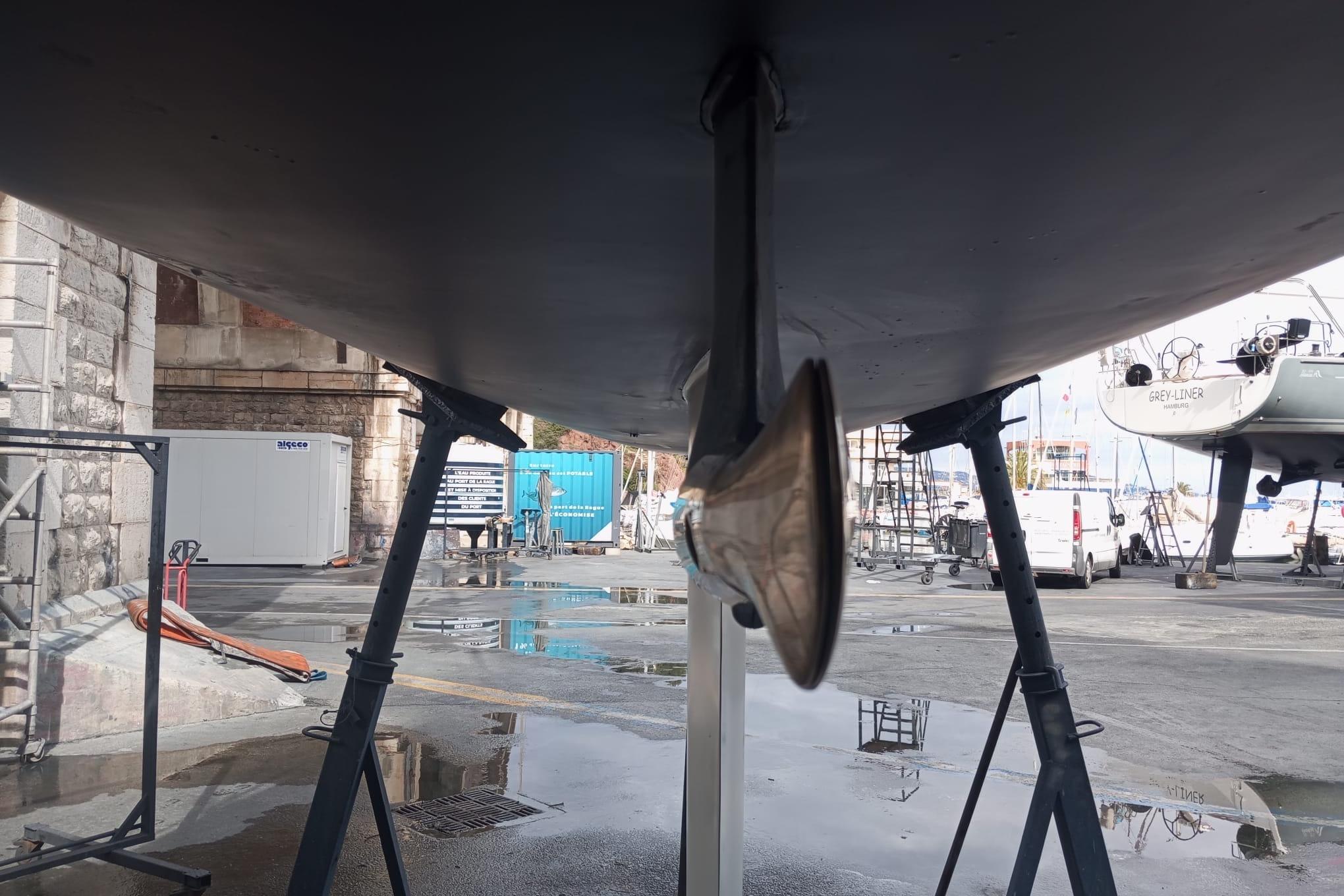 Underneath view of a 2003 Solaris 36 OD sailboat on stands in a shipyard.