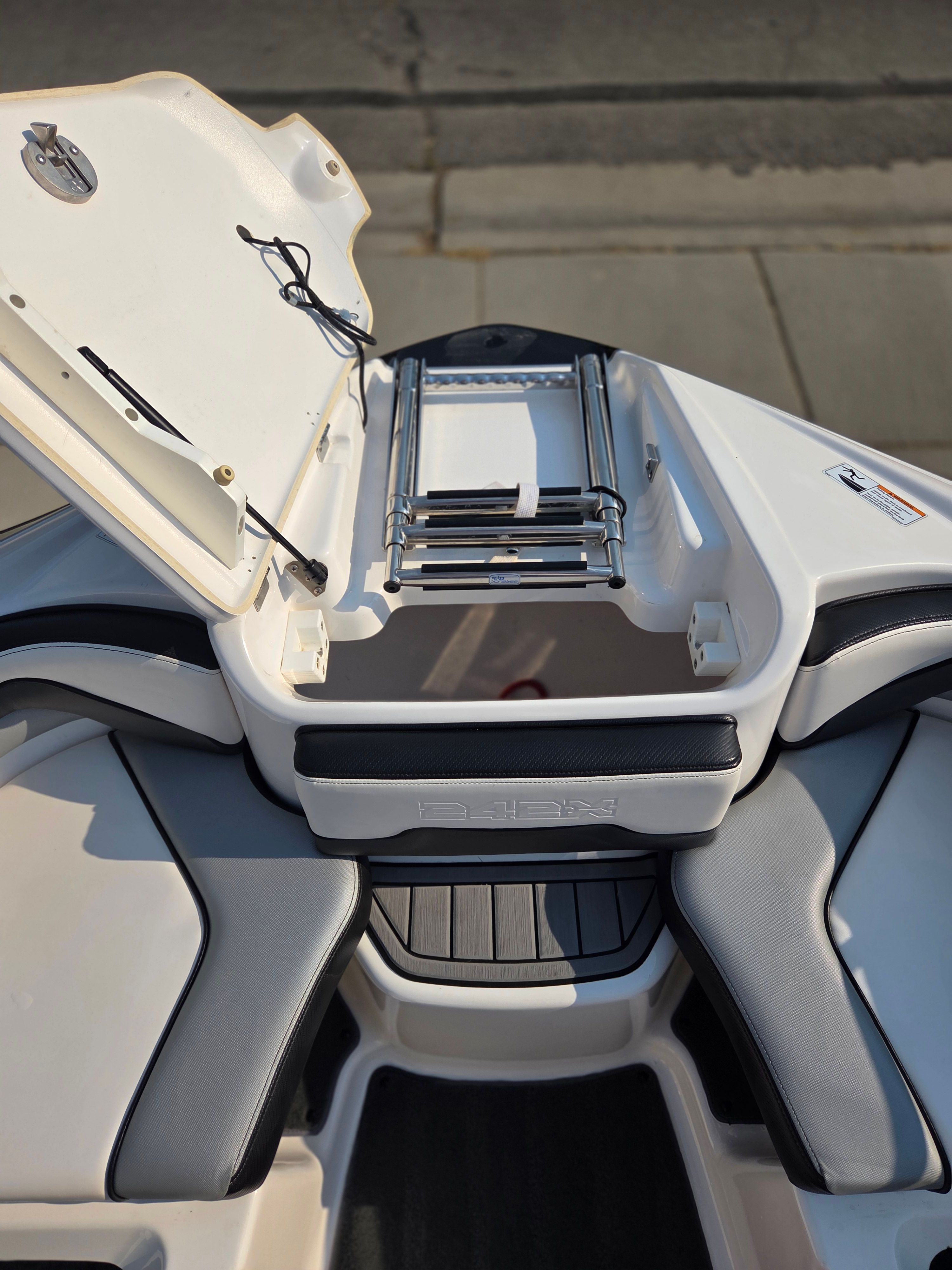 The image shows the stern of a Yamaha 242X E-Series boat with a foldable swim ladder.