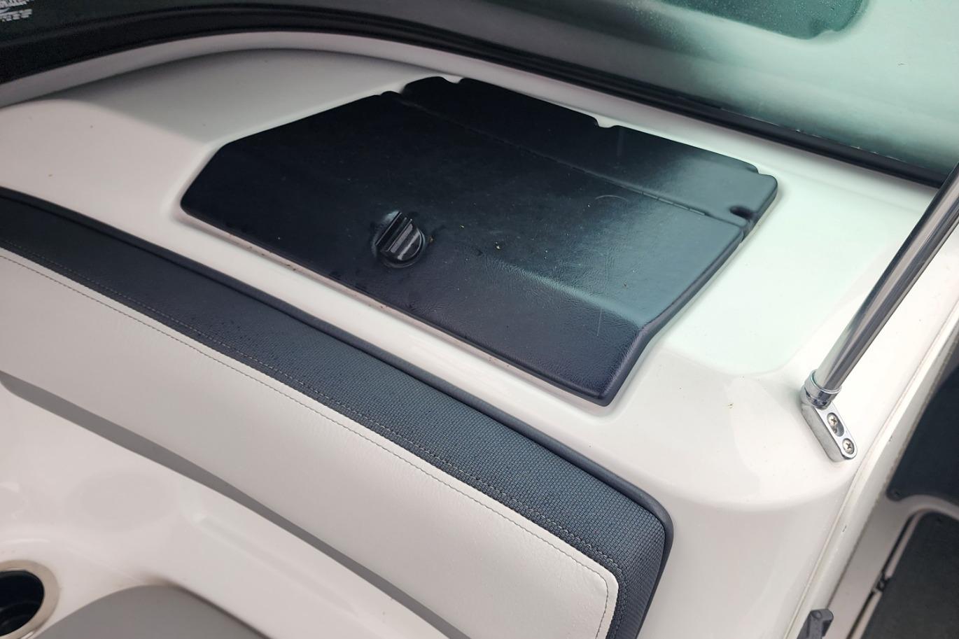 Interior detail of a 2015 Yamaha Boats 212X, featuring a black storage compartment.