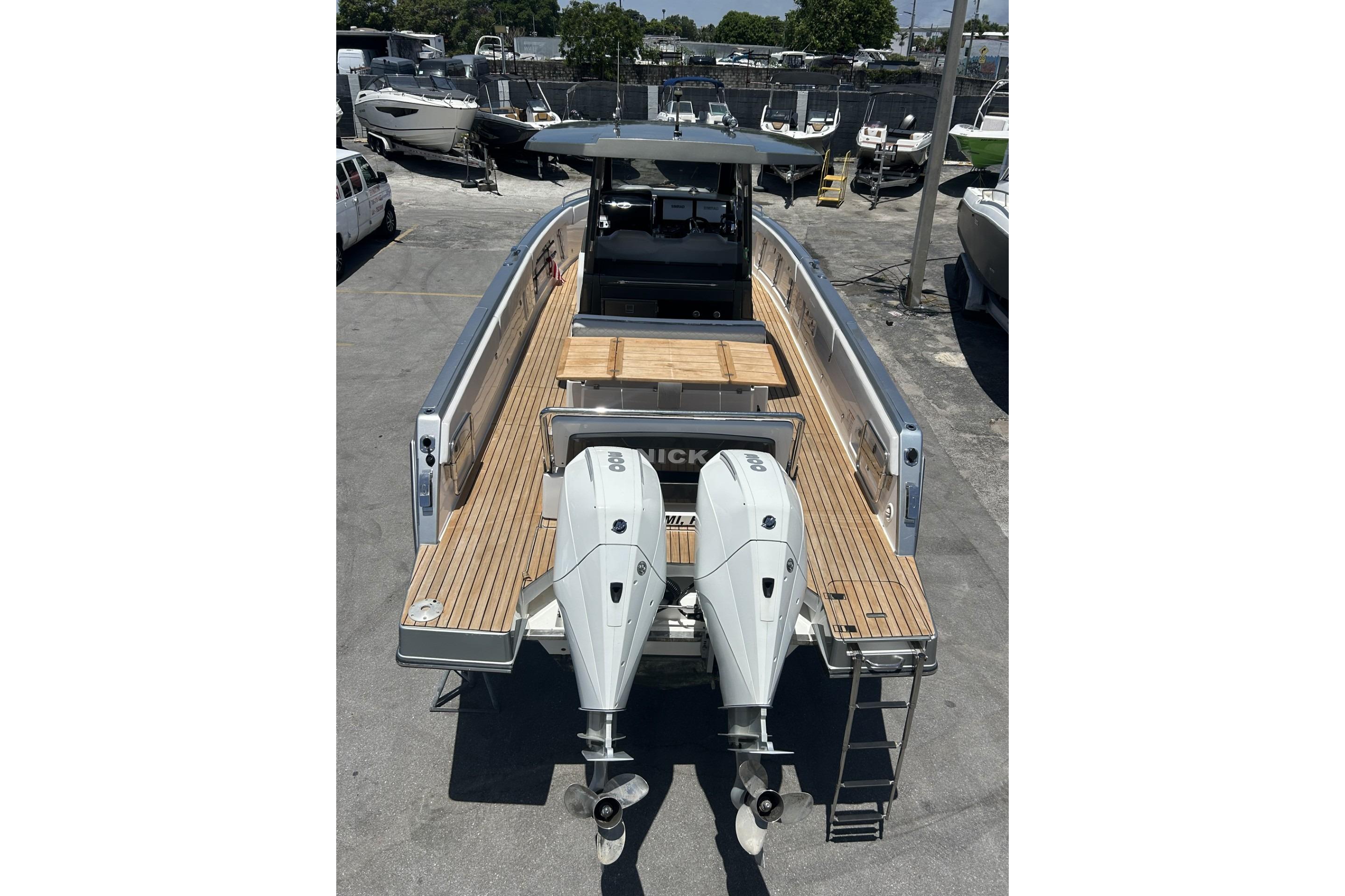 2023 Schaefer V33 boat with dual outboard engines, docked in a marina.