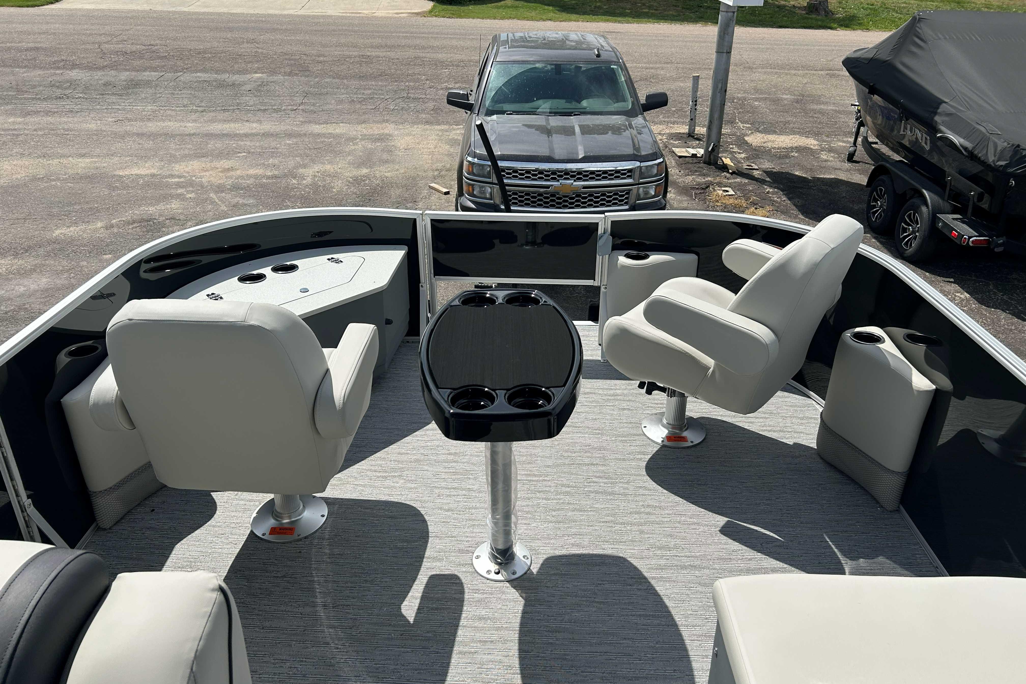 2026 Starcraft EX 22 FD boat interior with seating and table, parked on a trailer.