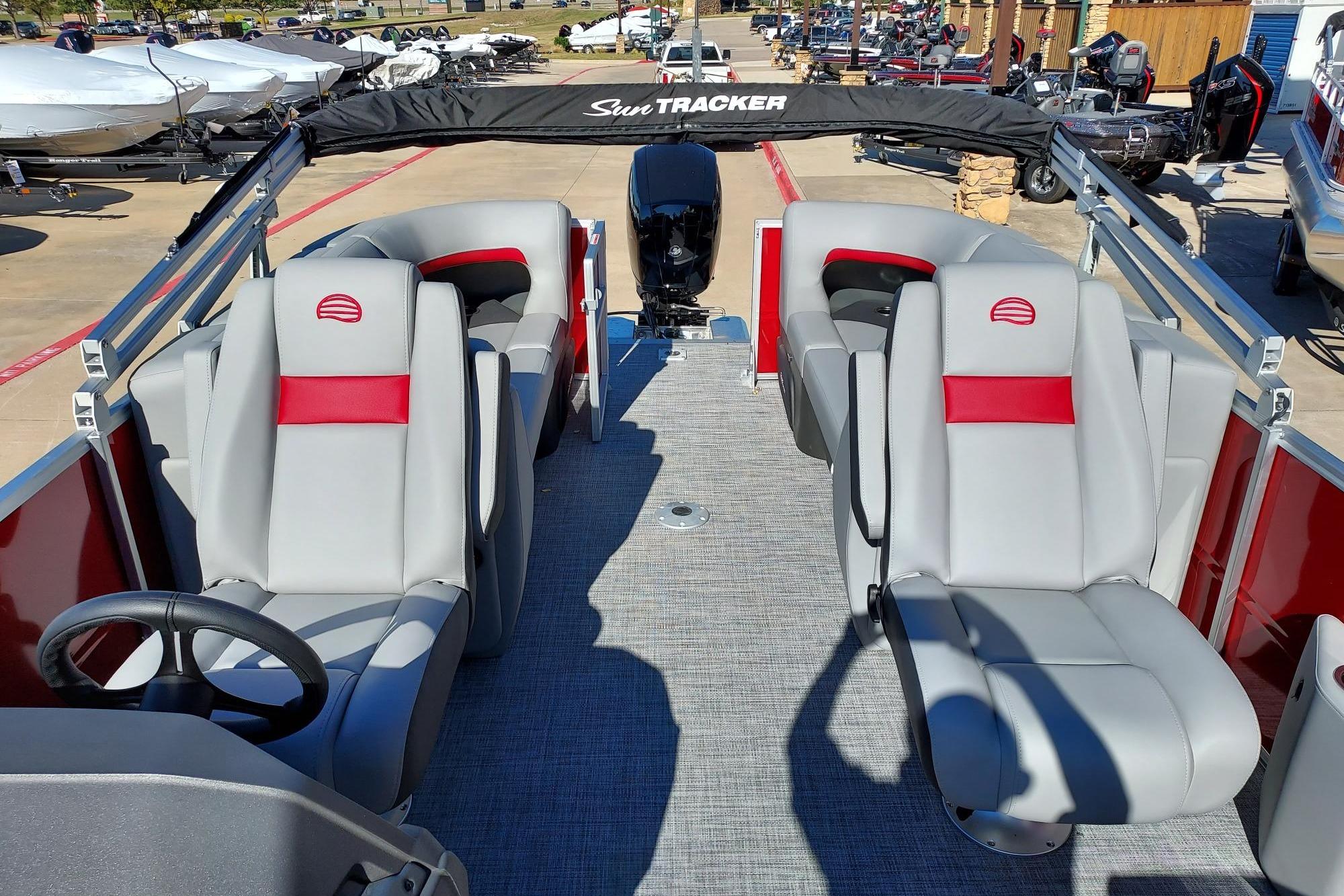 2026 Sun Tracker Party Barge 22 DLX with gray and red seating, outdoor display.