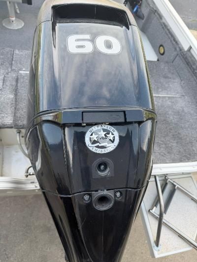 Close-up of a black outboard motor with the number 60, mounted on a boat.