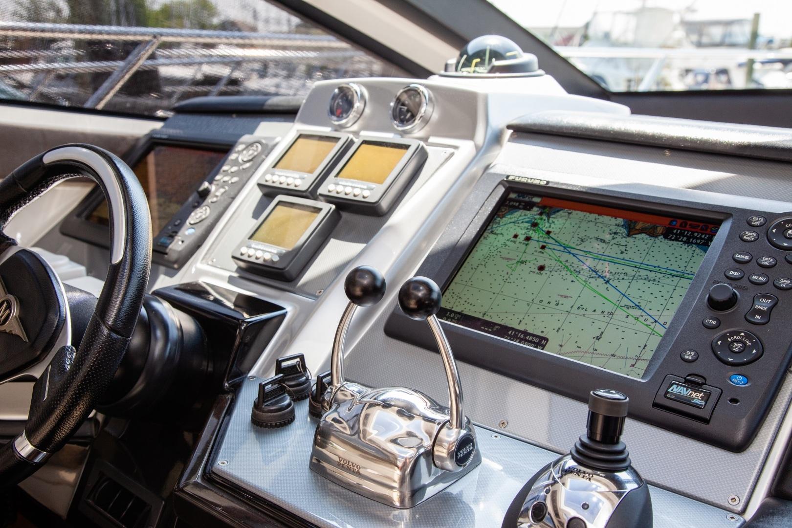 Dashboard of a 2009 Marquis 500 Sport Coupe yacht with navigation controls and screens.