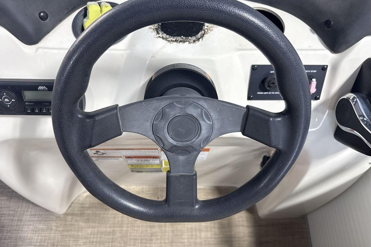 Steering wheel of a 2018 Landau Alure 212 Fish boat, featuring control panel and throttle.