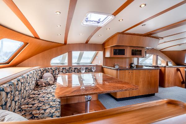 Luxurious interior of 2025 Shuttleworth 52 AeroRig yacht with elegant wood finish and seating area.