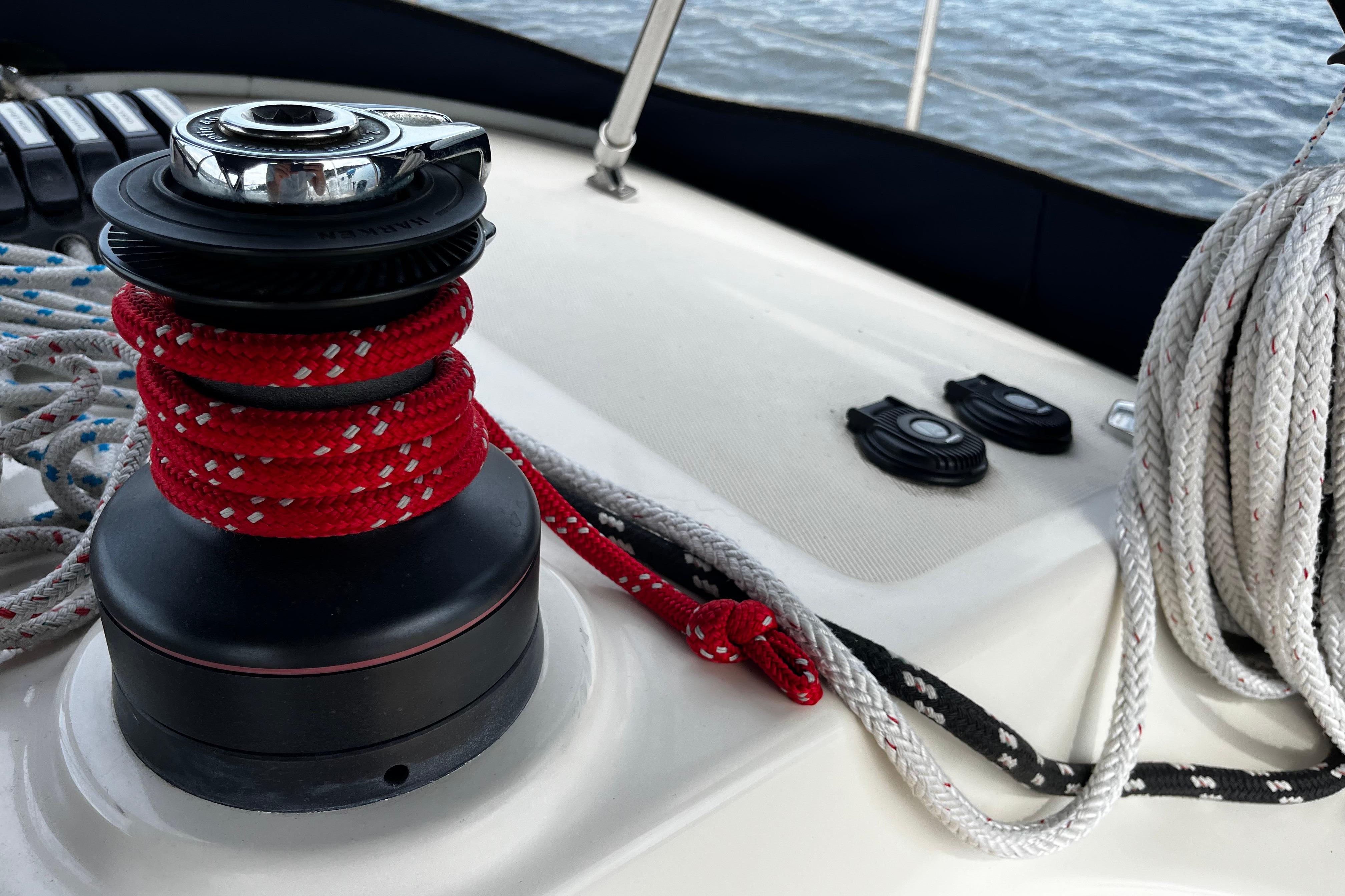 Winch and ropes on 2004 Hanse 411 sailboat deck, near water.