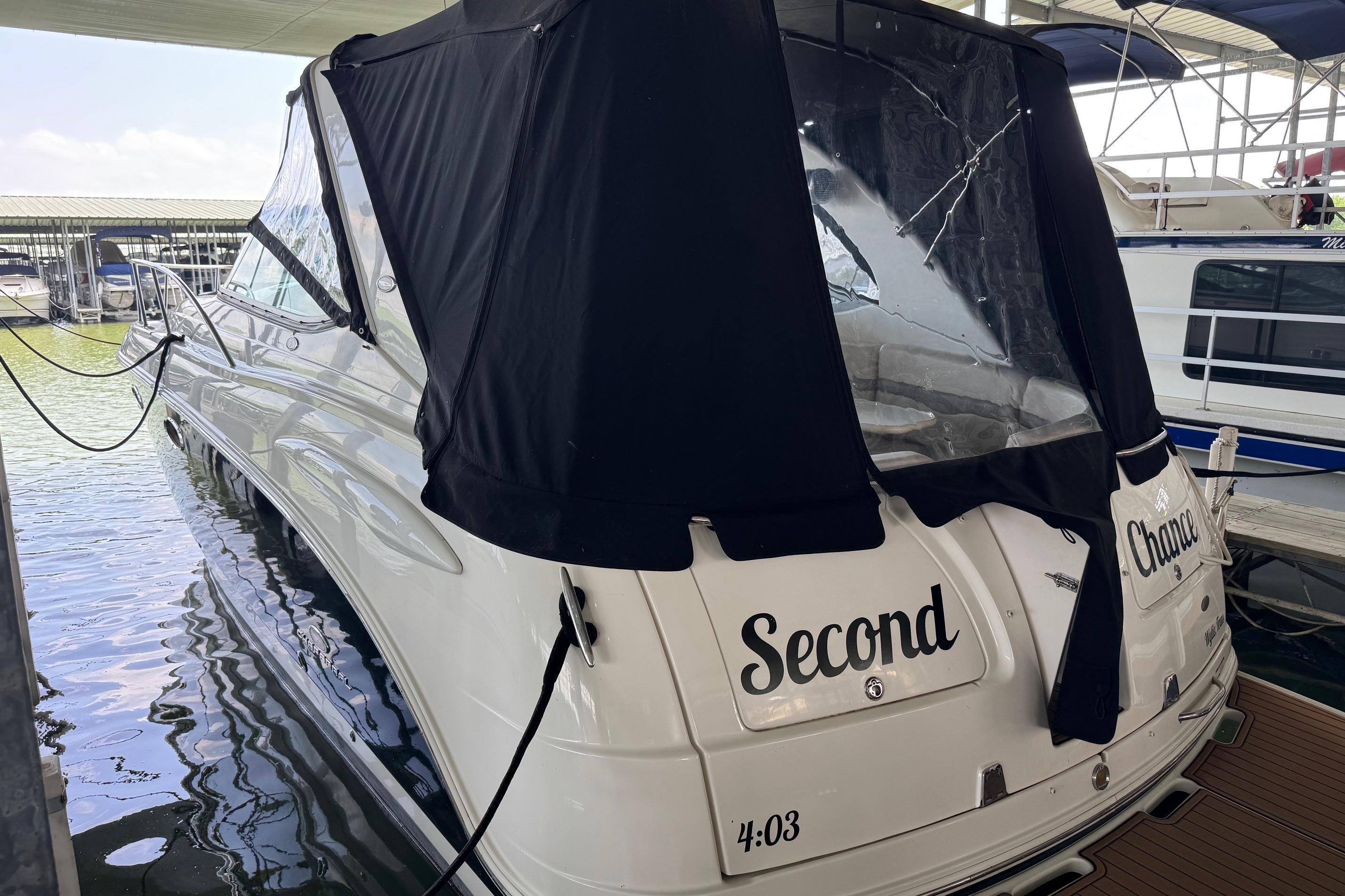 2006 Chaparral 330 Signature boat docked, featuring black canopy and "Second Chance" name.
