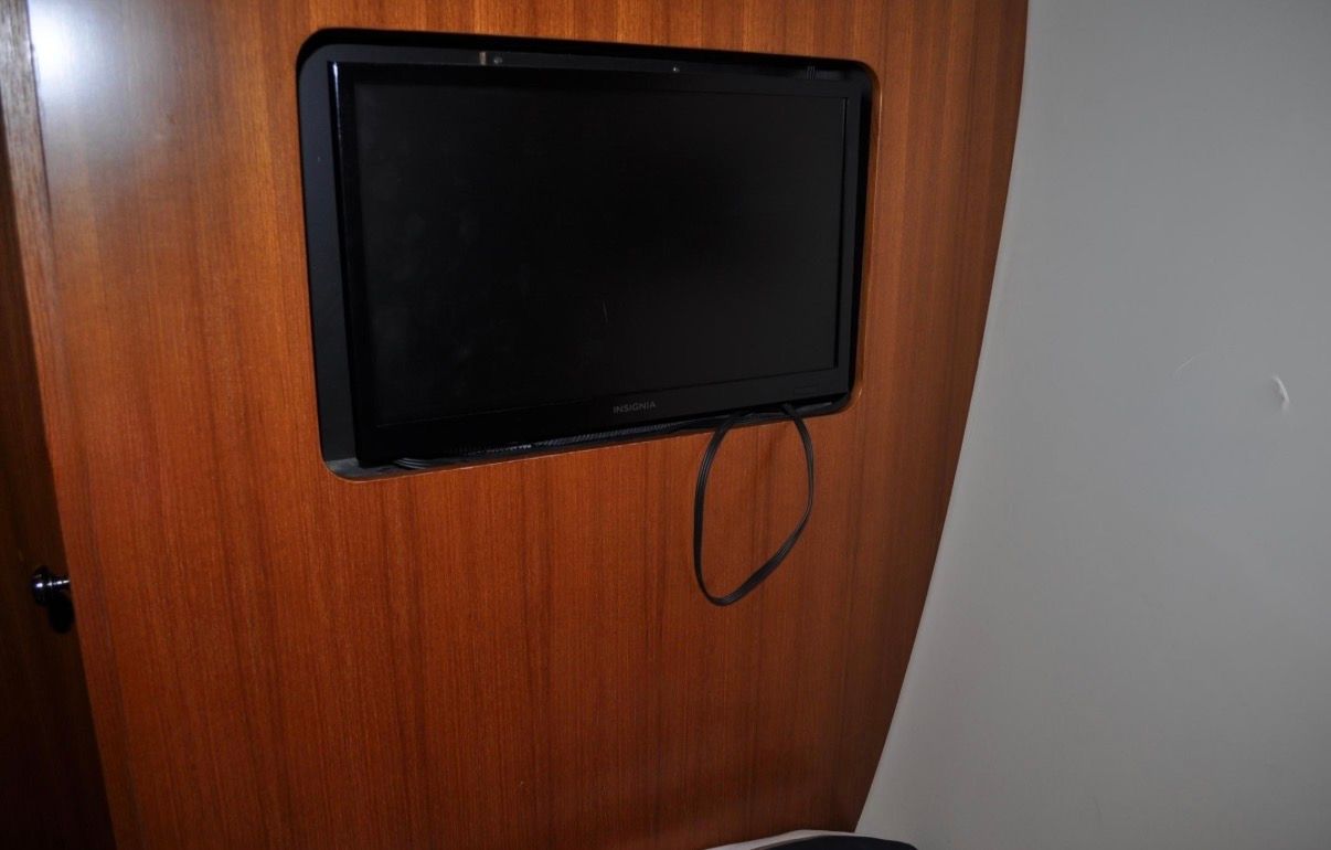 A flat-screen TV is mounted into a wooden wall.