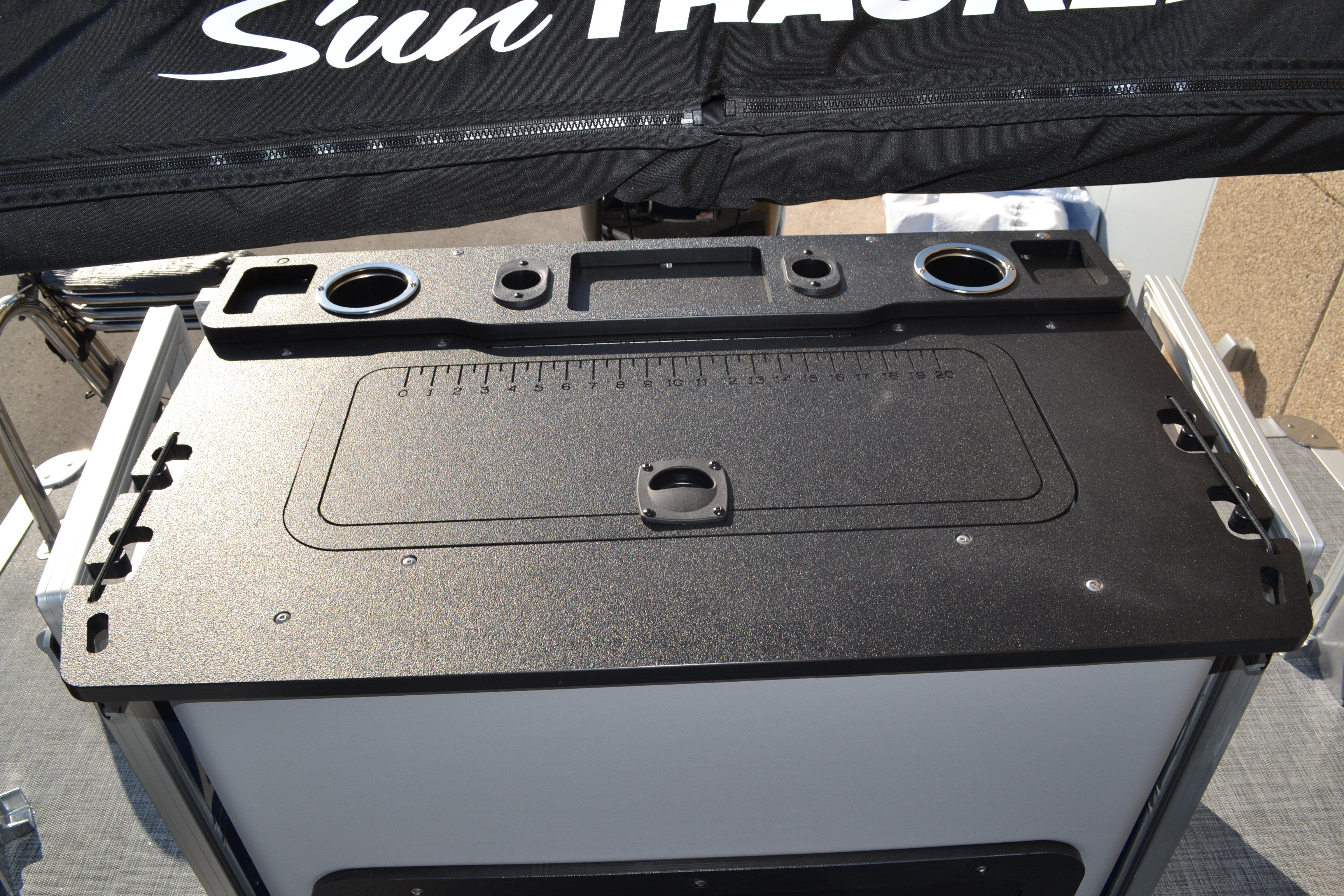 2026 Sun Tracker SportFish 22 XP3 fishing station with rod holders and measuring board.
