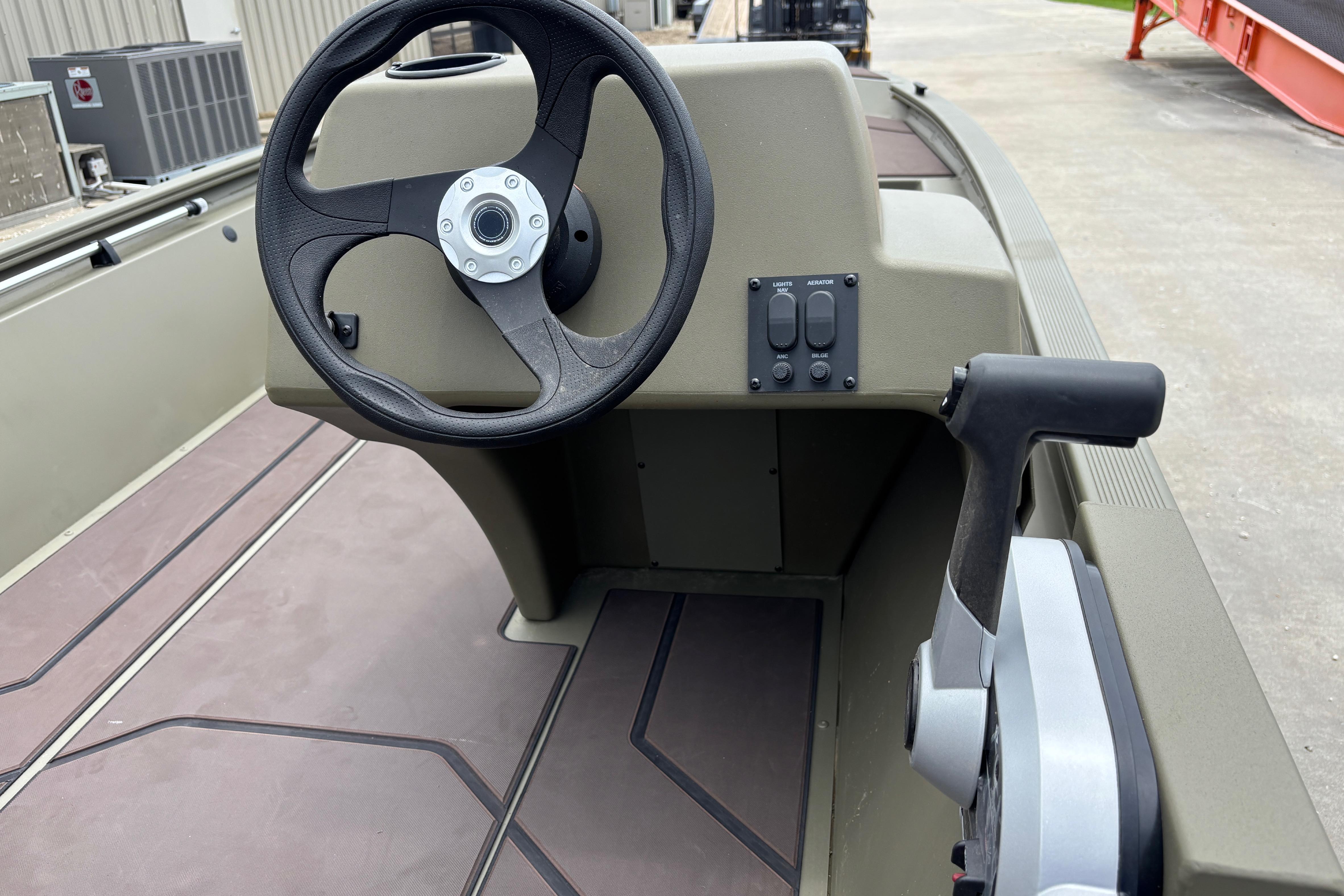 2026 Tracker Grizzly 1648 SC boat steering console with controls and steering wheel.