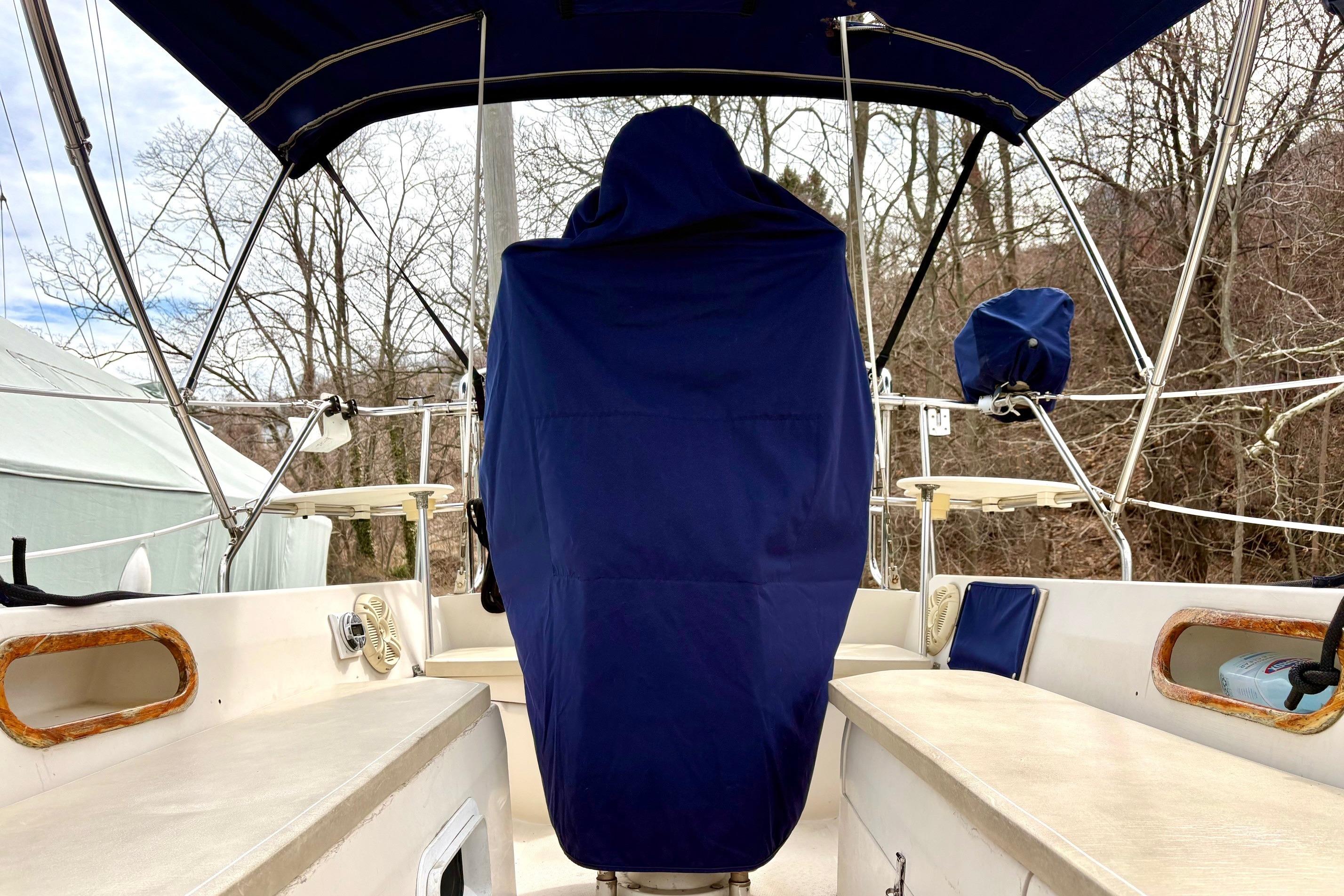 1992 Catalina 34 sailboat cockpit with blue covers and canopy, surrounded by trees.