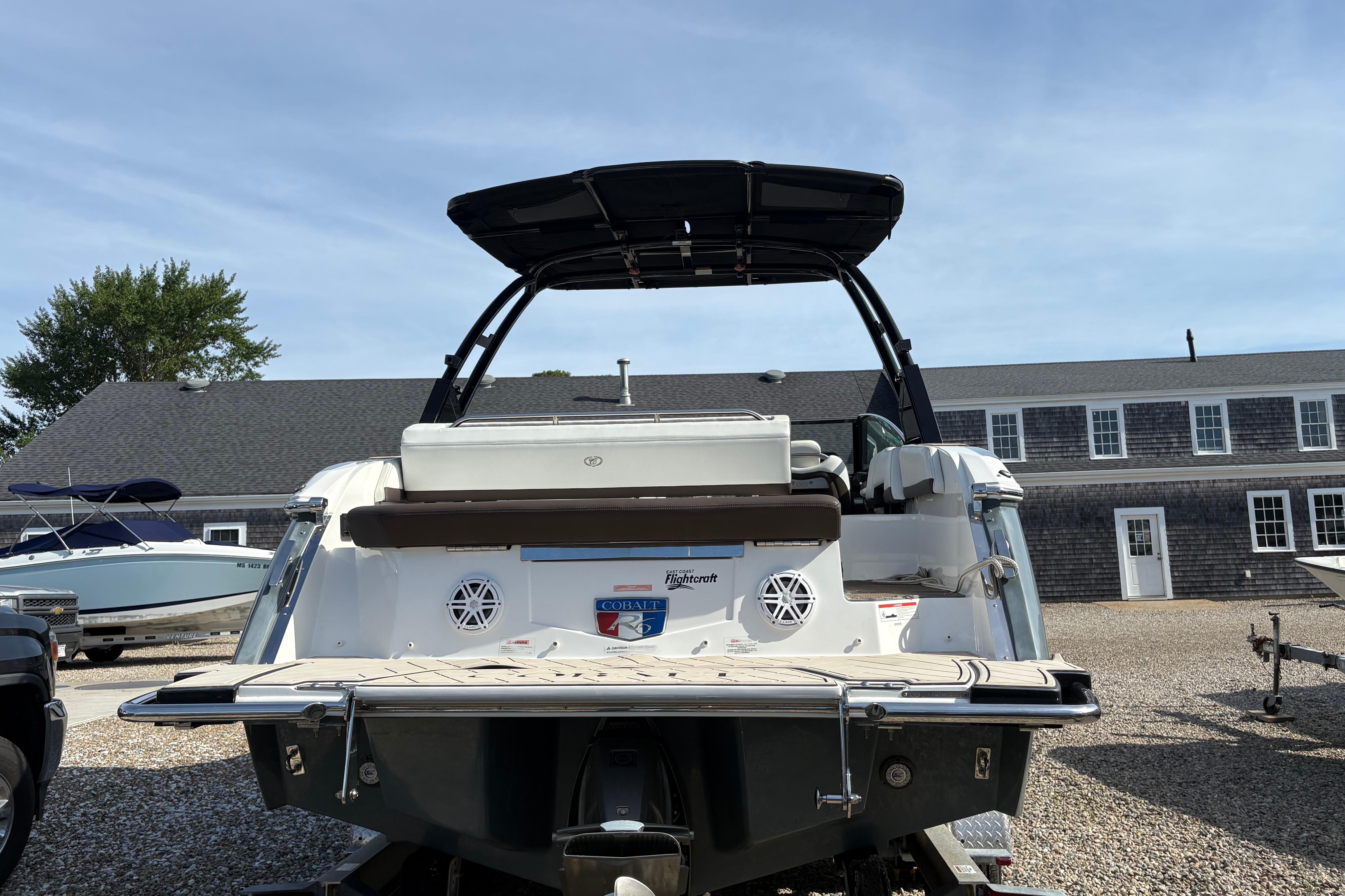 2022 Cobalt R6 boat with wakeboard tower, parked outdoors.
