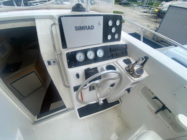 2001 Boston Whaler 28 Conquest helm with Simrad navigation system and steering wheel.