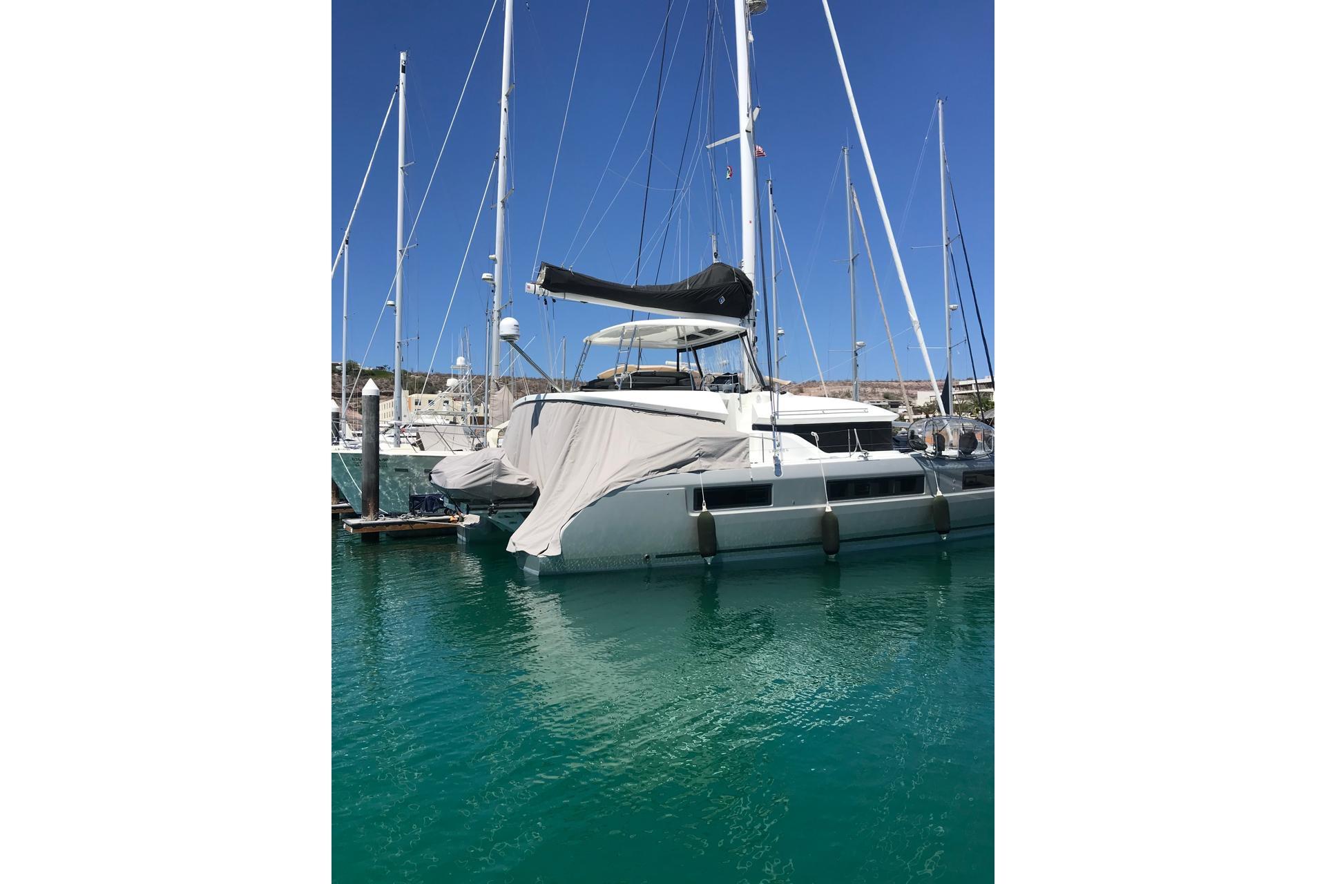 2020 Lagoon 50 catamaran docked in a marina with clear blue water.