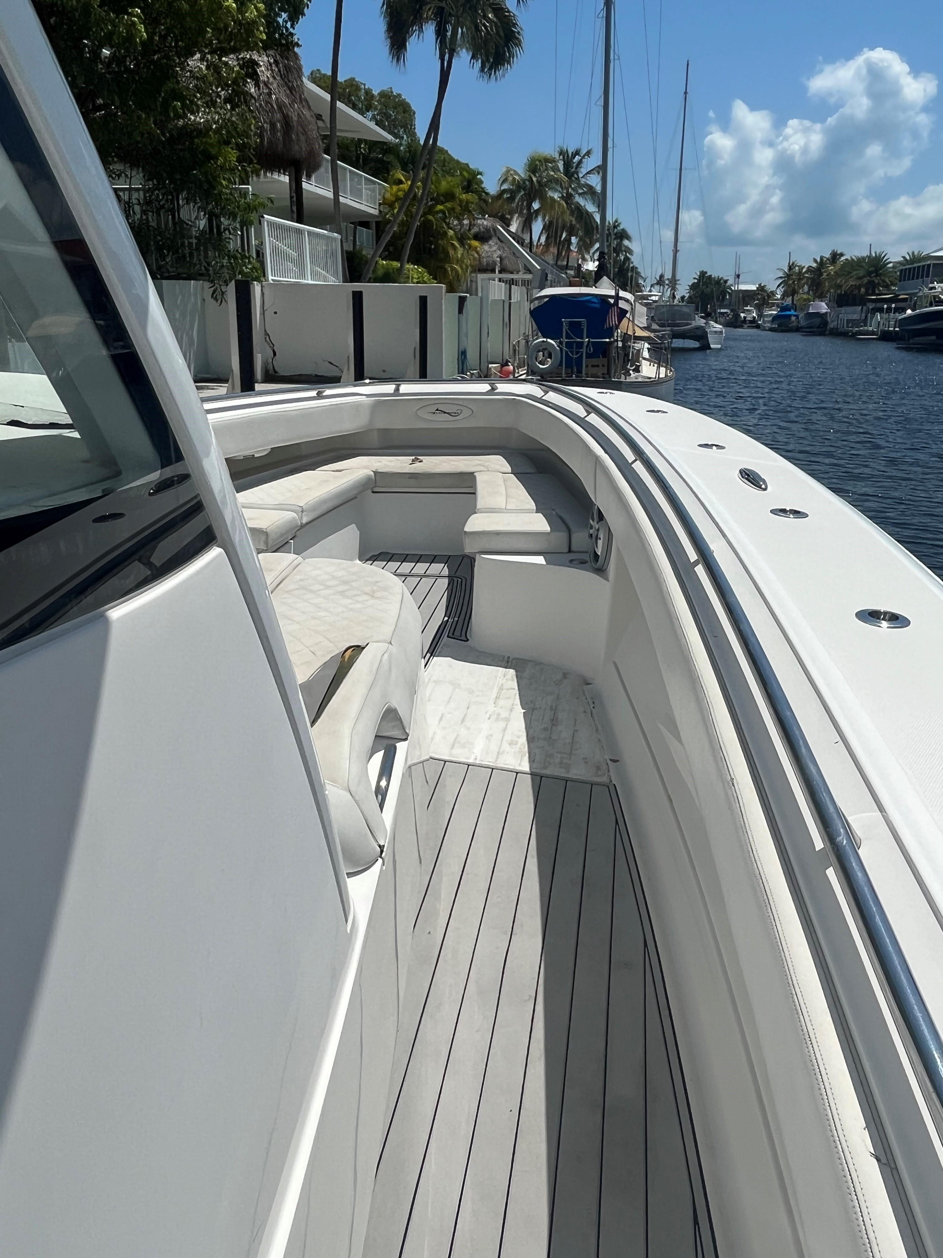 2018 Blackwater 43 boat docked by a canal, featuring sleek white design and spacious seating.