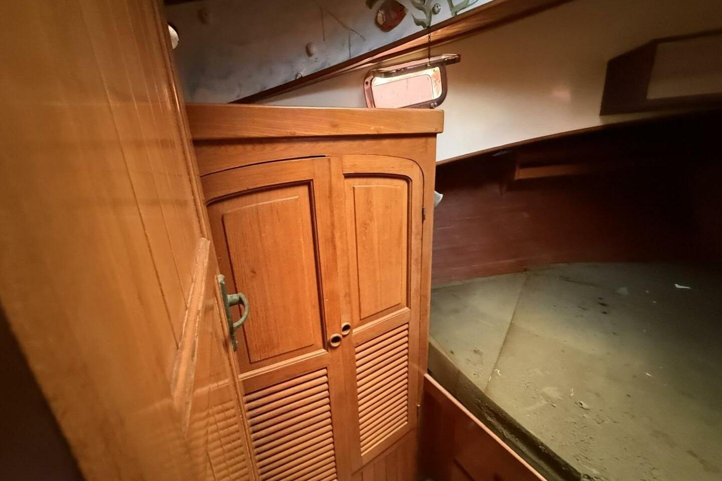 Wooden interior of 1986 Lord Nelson 37 #49 sailboat, featuring a cabinet and cozy cabin space.