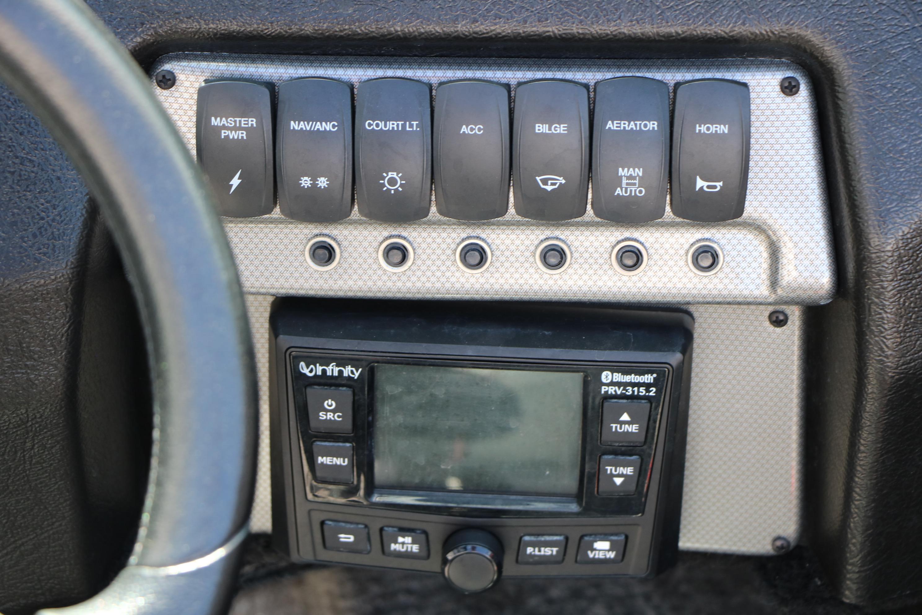 Control panel of 2023 Alumacraft Competitor FSX 185 boat with switches and Bluetooth stereo.