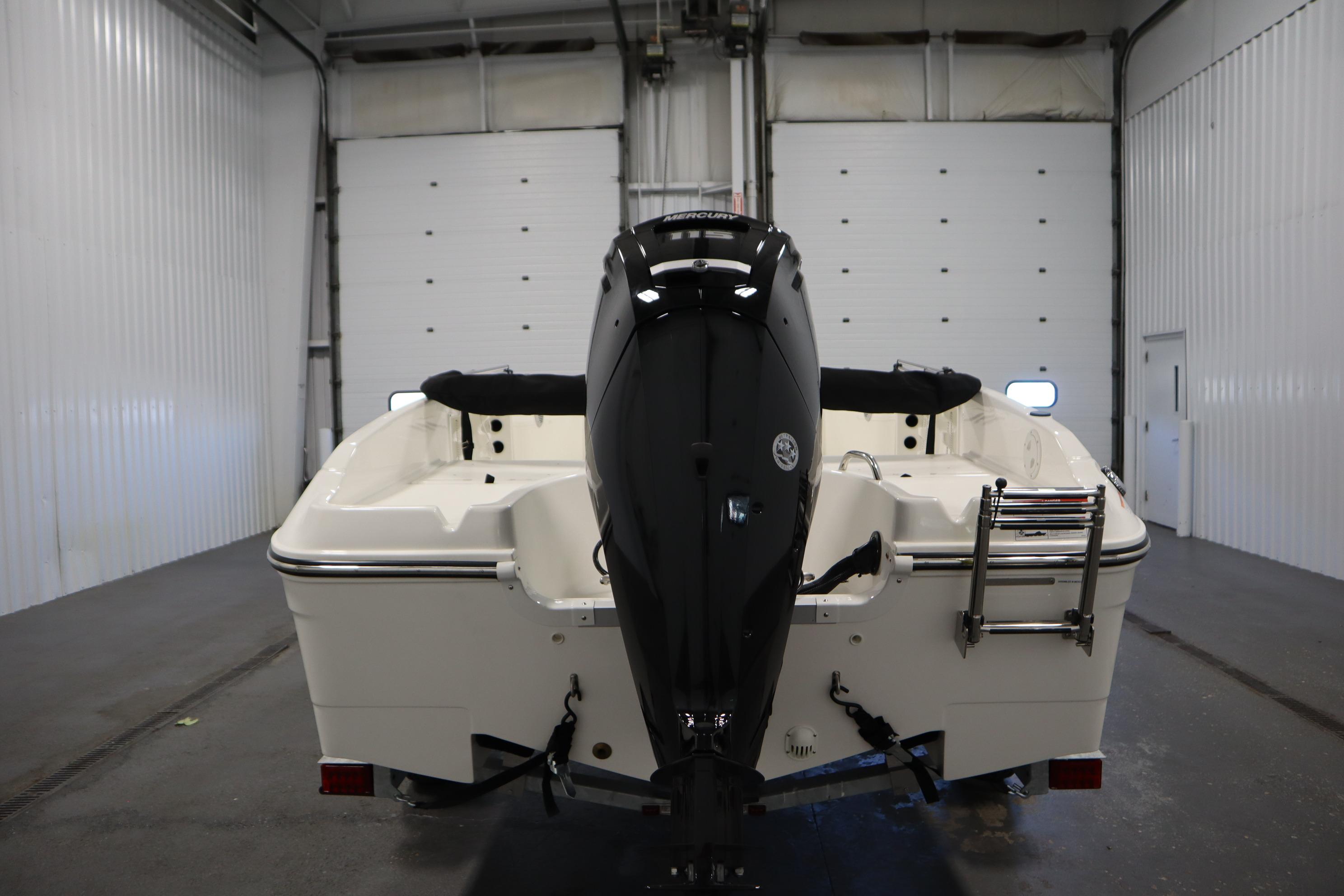 2026 Bayliner Trophy T18 boat in a garage, rear view with outboard motor.