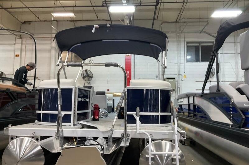 2026 Bennington 22 SSRSF pontoon boat in a showroom with canopy and modern design.