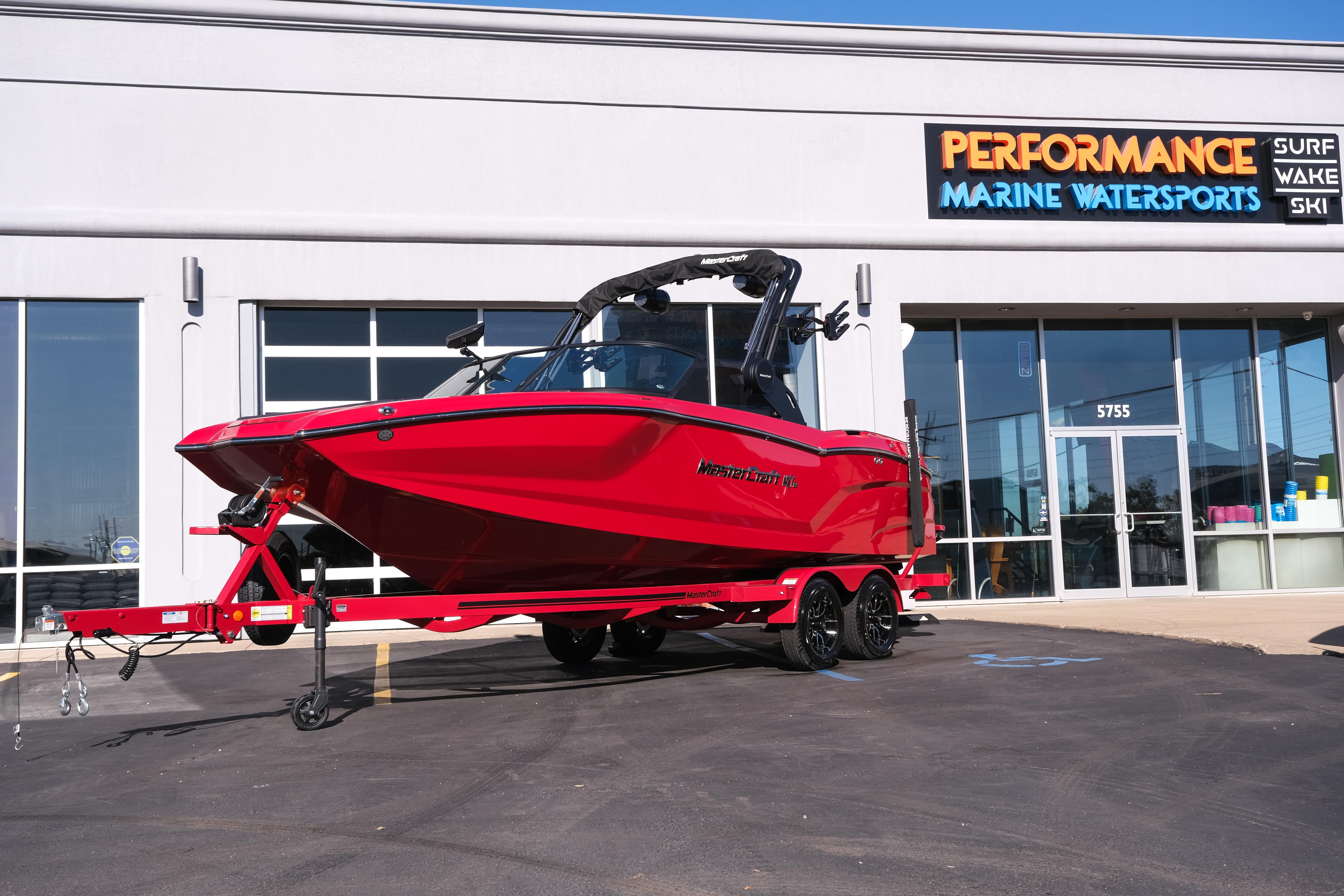2026 MasterCraft NXT22 boat in vibrant red outside Performance Marine Watersports store.