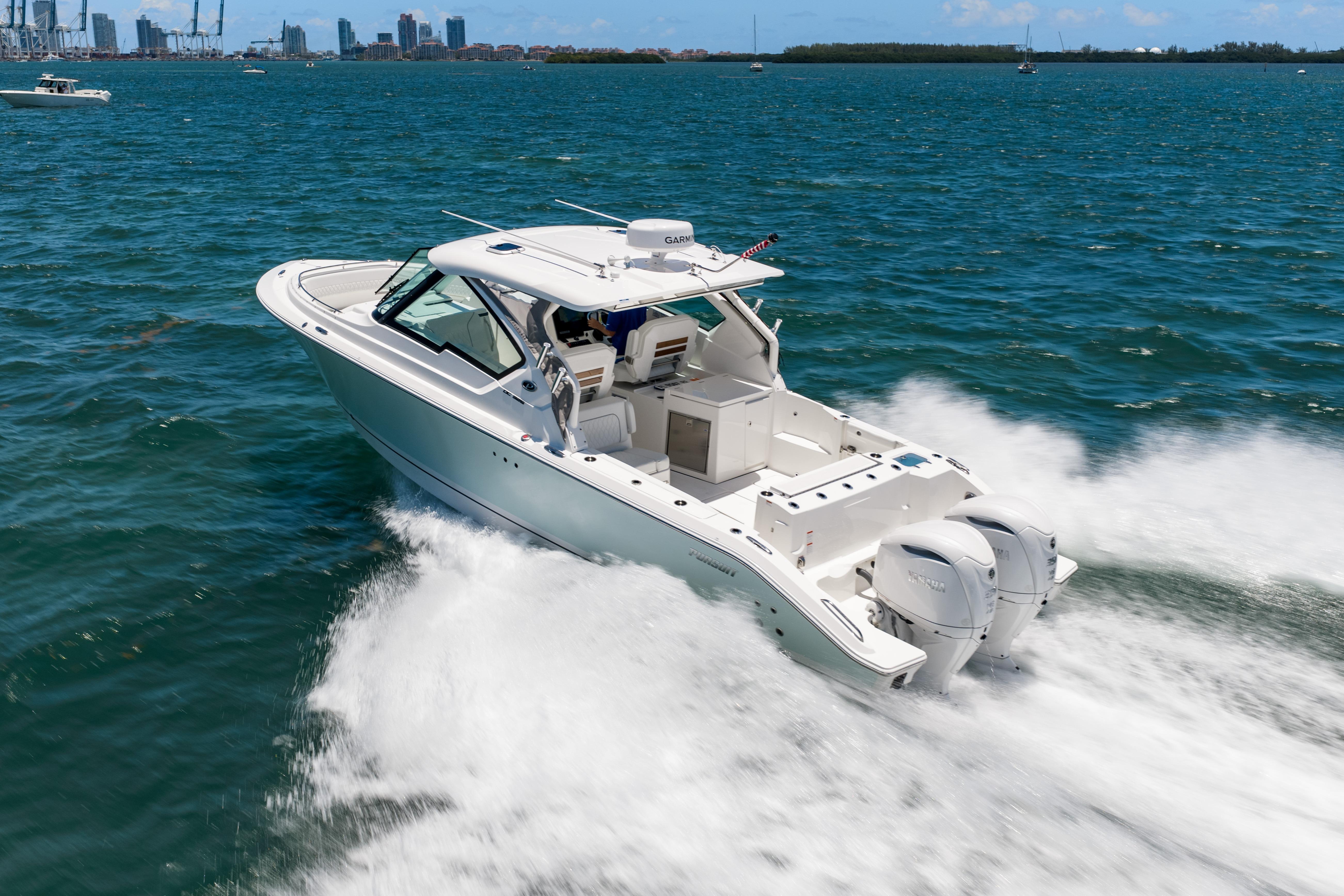 2026 Pursuit DC 326 Dual Console boat cruising on open water, city skyline in background.