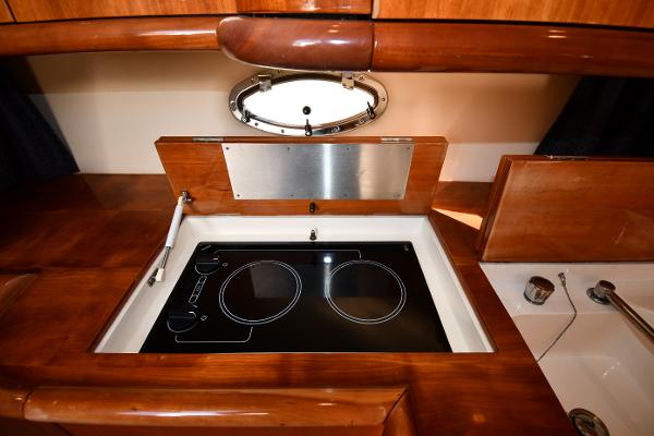 Sunseeker Camargue 47 yacht kitchen with electric stove, wooden cabinetry, and porthole window, 1997 model.