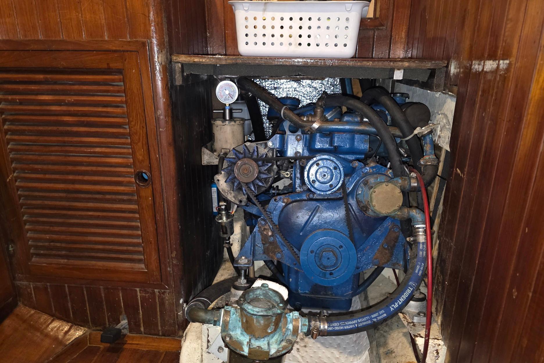 Engine compartment of a 1982 Tayana 37 sailboat, featuring a blue marine engine.