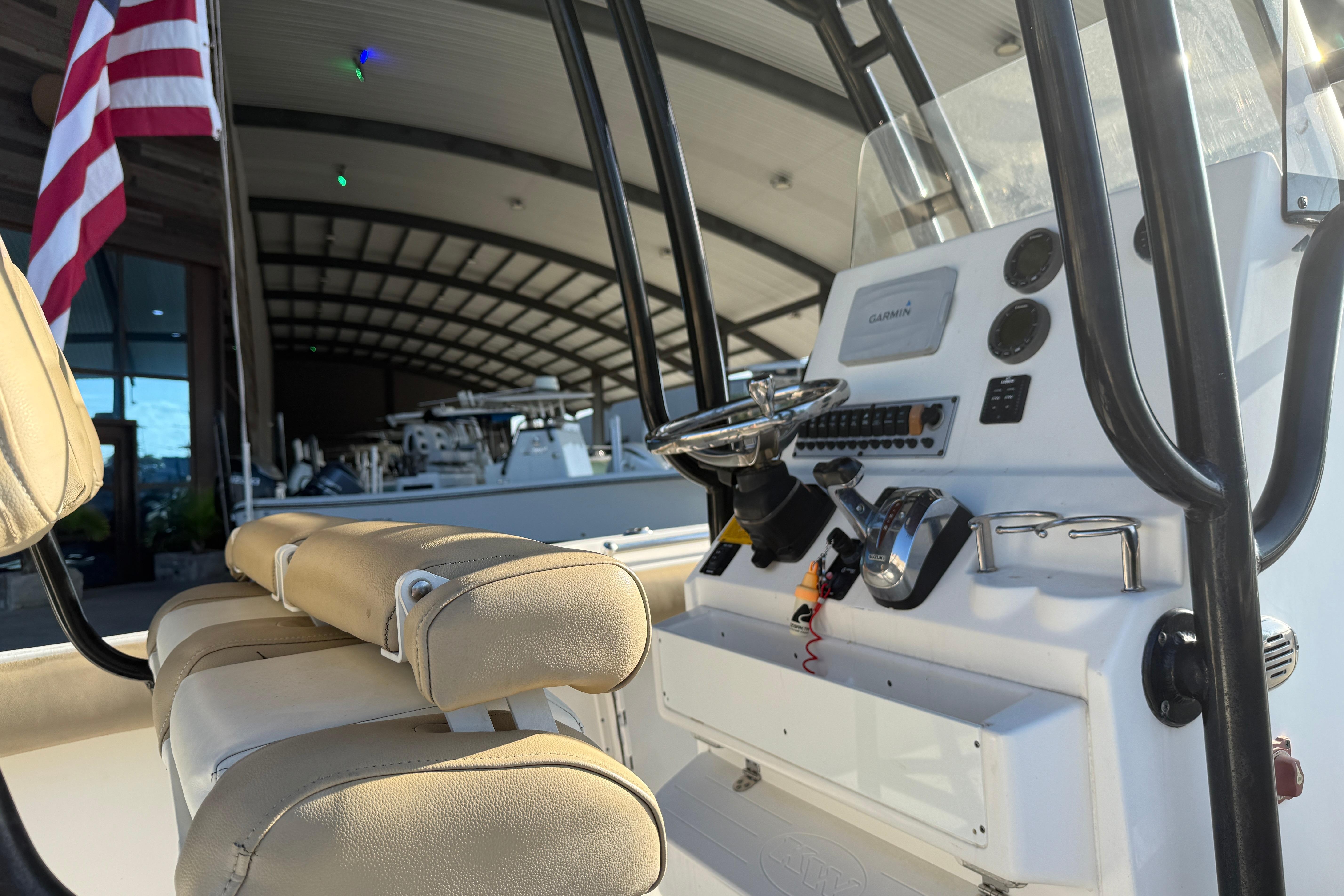 2016 Key West 239 FS boat interior with steering console and American flag.