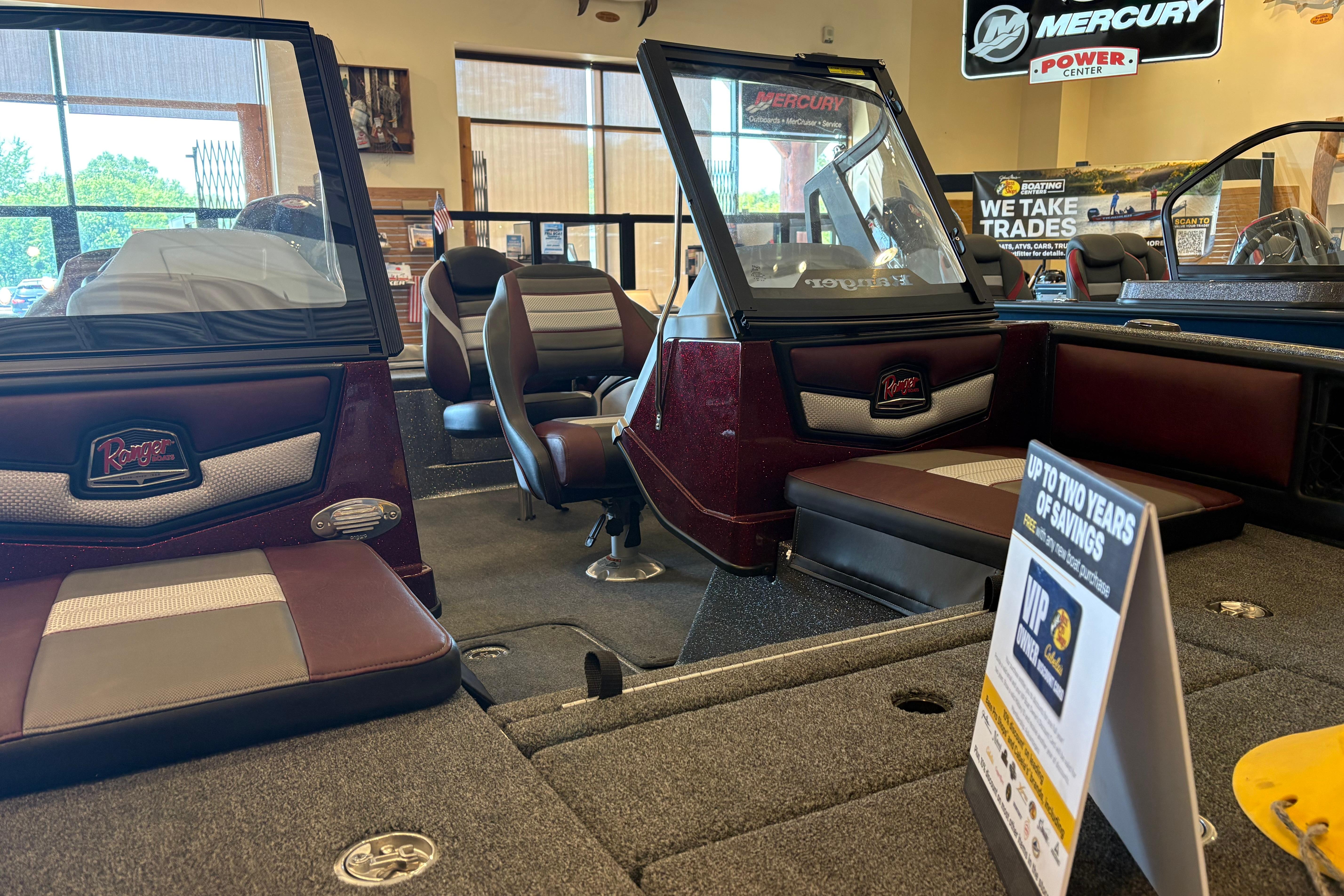 2026 Ranger 1850MS boat interior in showroom, featuring seating and promotional signage.