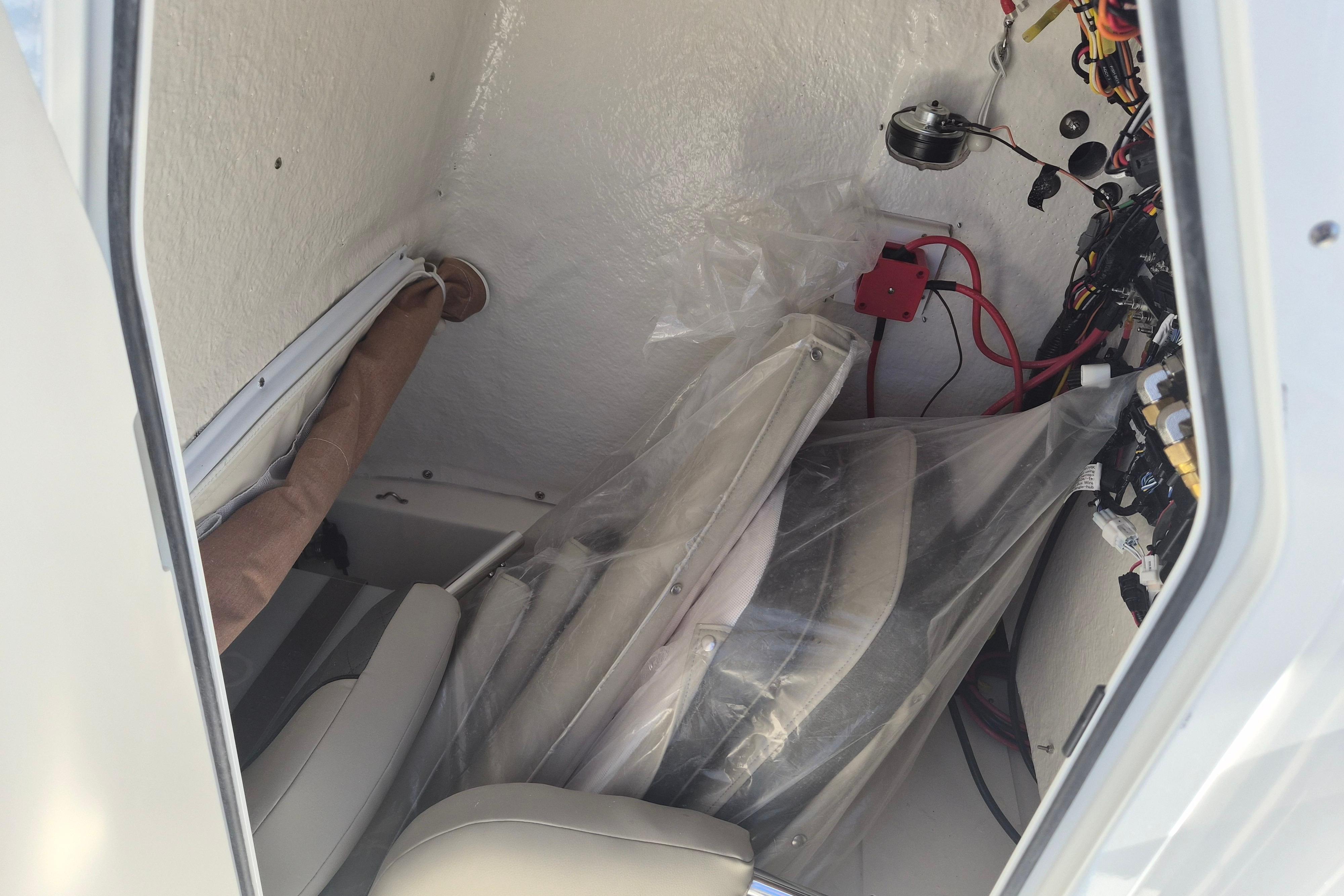 Interior view of a 2026 Key West 239 FS boat, showing wiring and storage area.