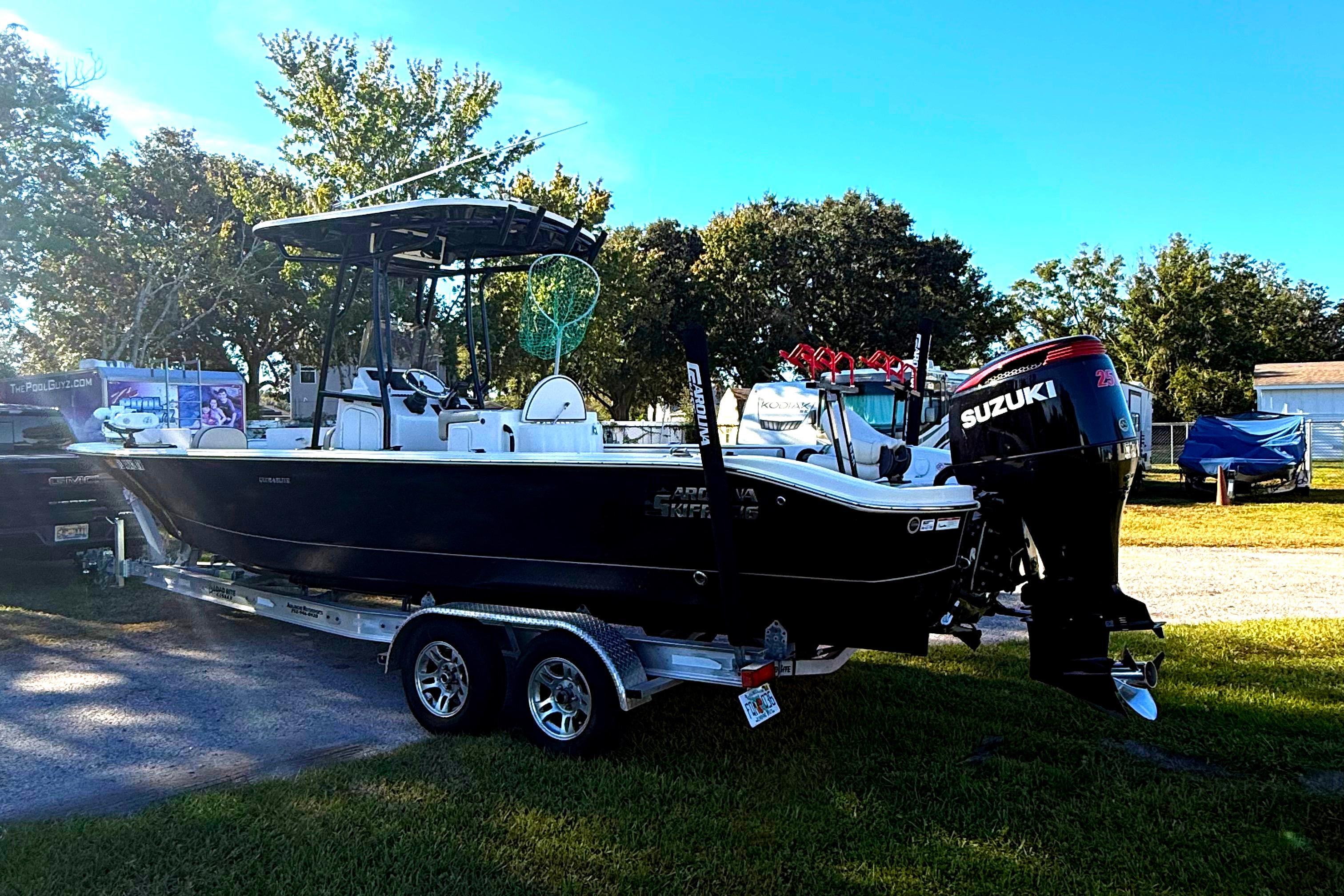 2021 Carolina Skiff 26 Ultra Elite boat on trailer with Suzuki outboard motor.