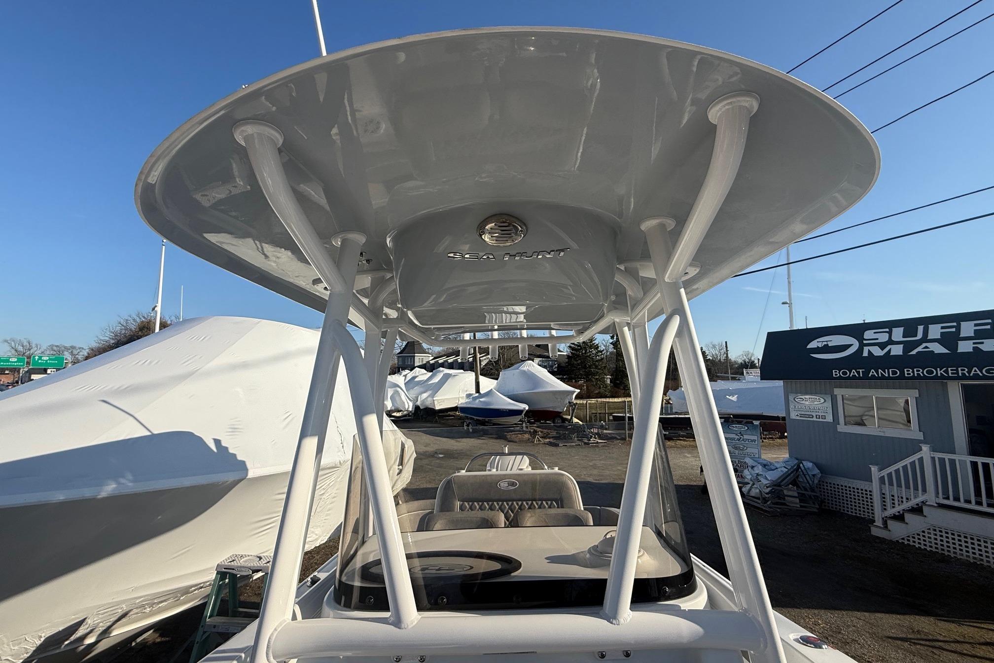 2026 Sea Hunt Ultra 229 boat with T-top at a marina.